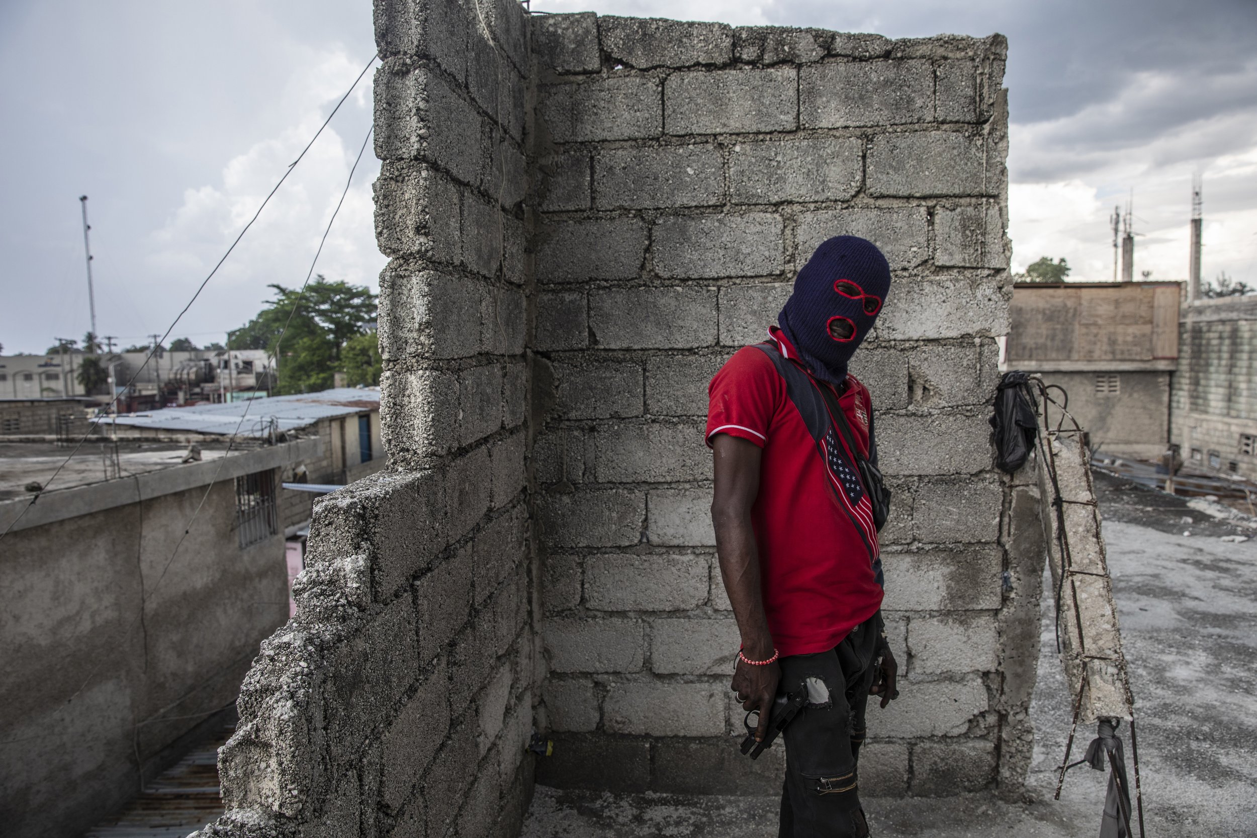  A gang member, wearing a balaclava and holding a gun, poses for a photo in the Portail Leogane neighborhood of Port-au-Prince, Haiti, on Sept. 16, 2021. (AP Photo/Rodrigo Abd) 