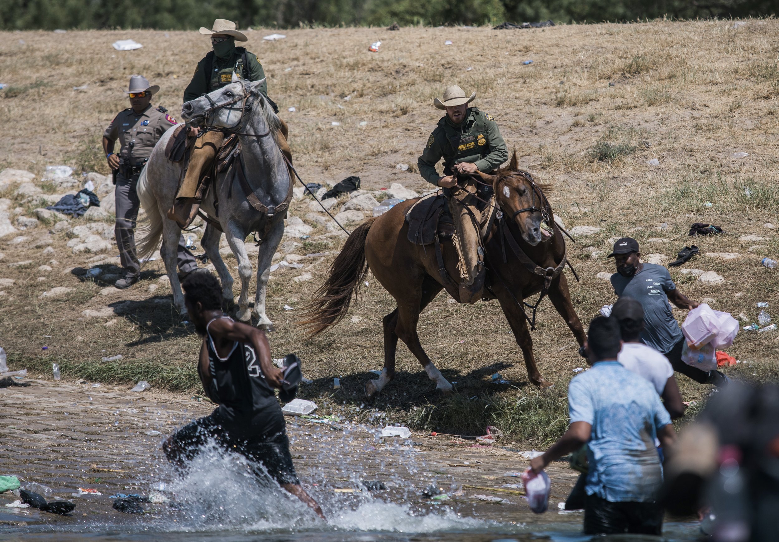  U.S. Customs and Border Protection mounted officers attempt to contain migrants, mostly from Haiti, as they cross the Rio Grande from Ciudad Acuña, Mexico, into Del Rio, Texas, on Sept. 19, 2021. (AP Photo/Felix Marquez) 