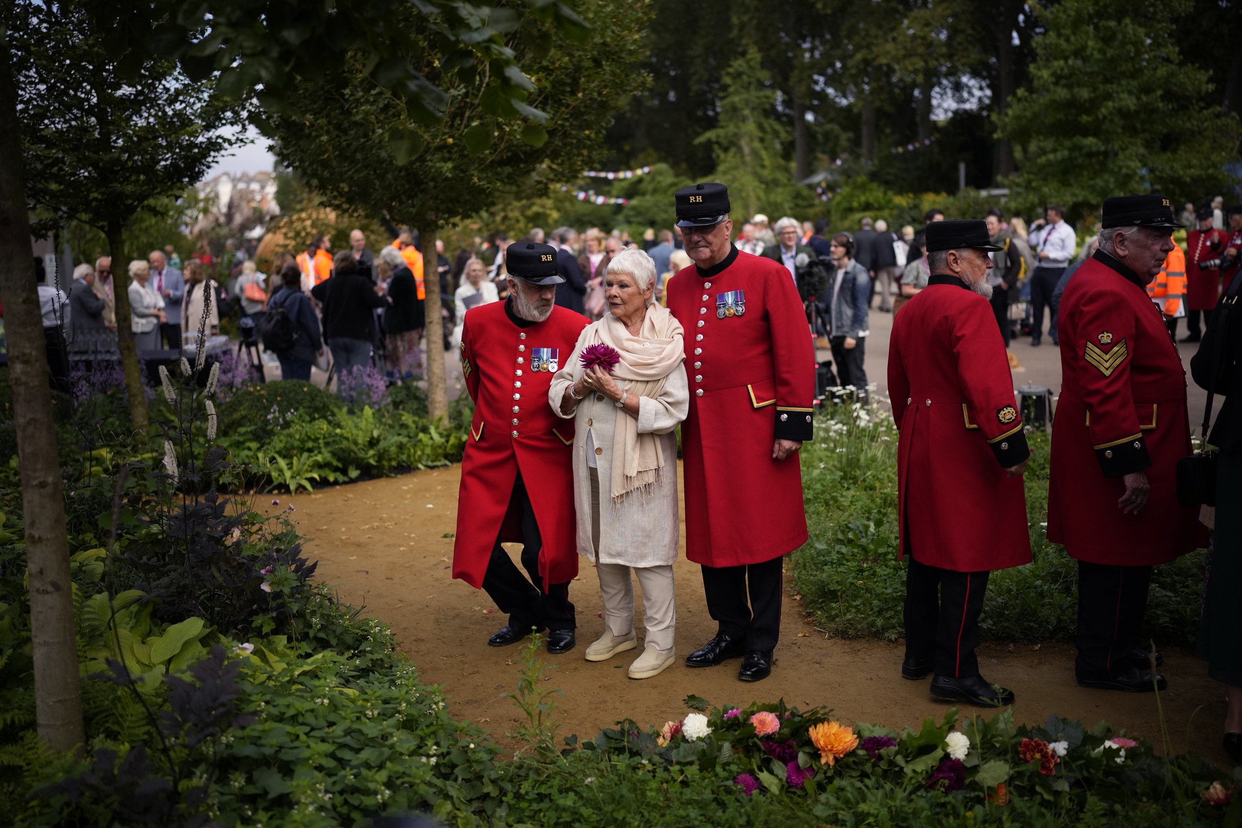  Chelsea Pensioners pose for photographs with British actress Dame Judi Dench as she officially opens "The Queen's Green Canopy" show garden at the Royal Horticultural Society’s Chelsea Flower Show in London, on Sept. 20, 2021. (AP Photo/Matt Dunham)