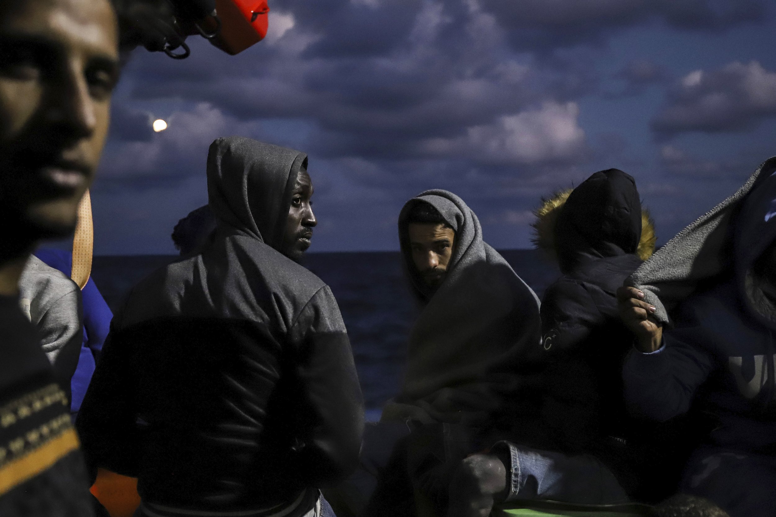  Migrants sit on the deck of the Sea Watch-3 rescue ship in the Maltese search and rescue zone on Oct. 19, 2021. In the prior two days, the ship had rescued 412 migrants from seven different boats in distress and was asking for a safe port to disemba
