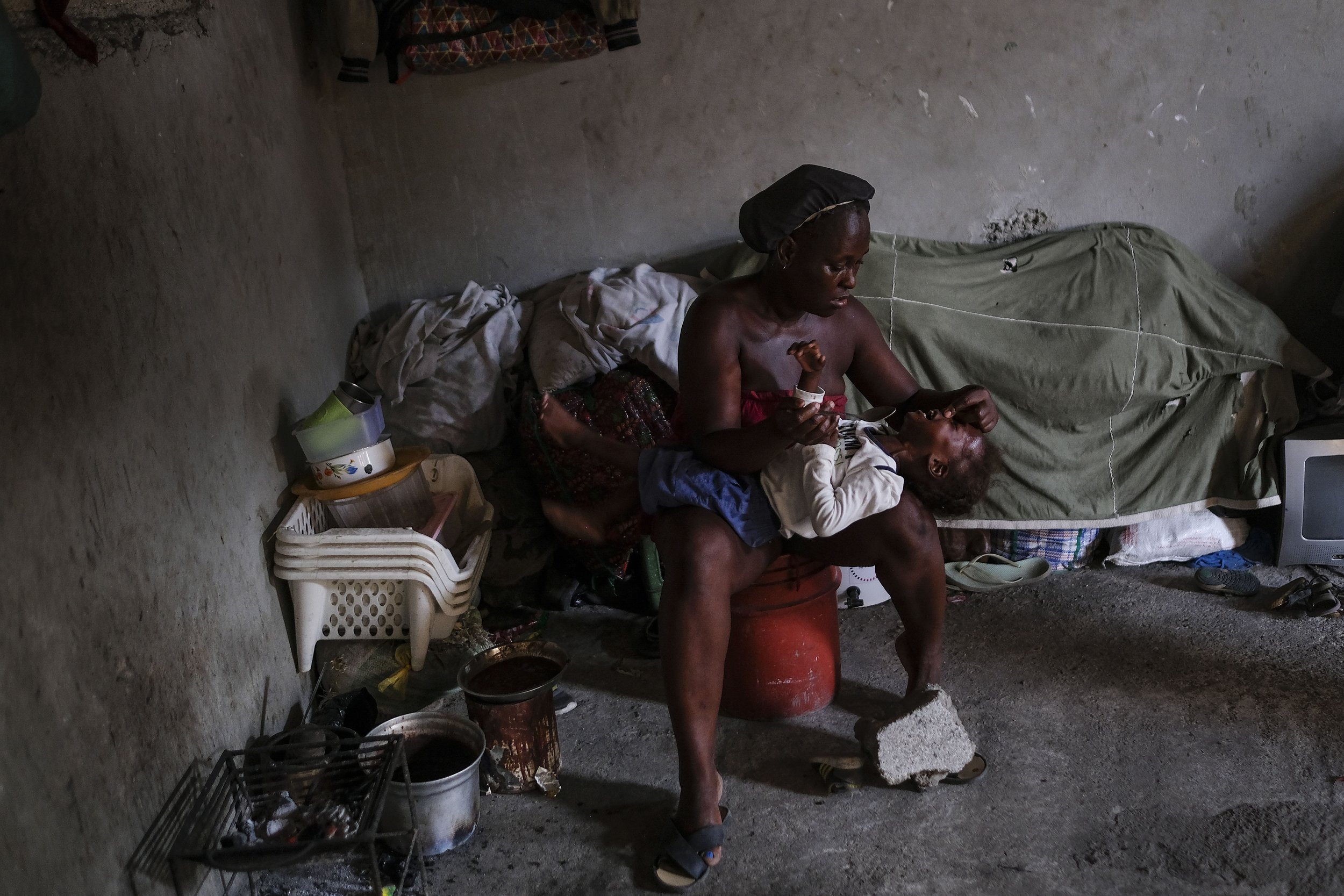 Daphne Lendor attempts to force feed beans to her daughter, who refuses to eat, at a shelter for families displaced by gang violence at the Saint Yves Church in Port-au-Prince, Haiti, on Oct. 29, 2021. (AP Photo/Matias Delacroix) 