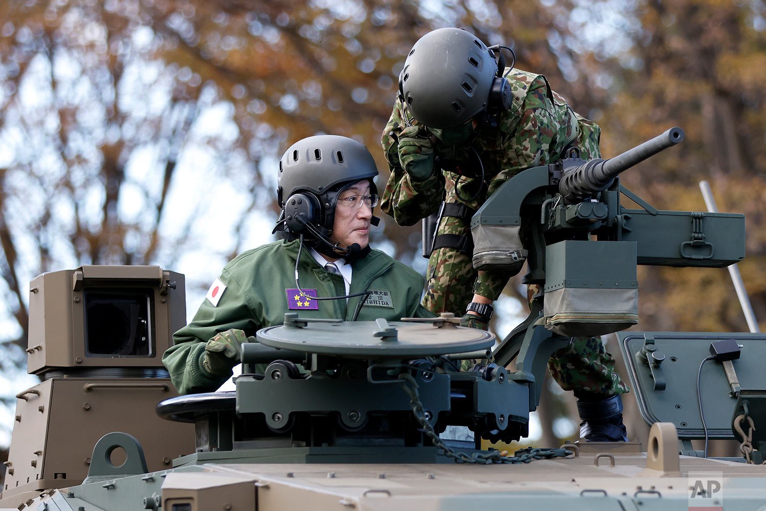  Japan's Prime Minister Fumio Kishida, left, rides on a Japan Ground Self-Defense Force (JGSDF) Type 10 tank during a review at the JGSDF Camp Asaka in Tokyo, Japan, Saturday, Nov. 27, 2021. (Kiyoshi Ota/Pool Photo via AP) 