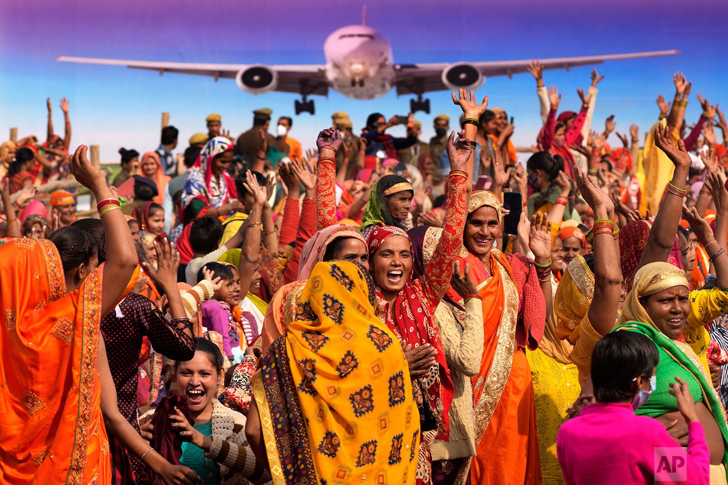  Women dance and shout slogans as they wait for the arrival of Indian prime minister Narendra Modi for the foundation laying ceremony of an international airport in Jewar, about 100 kilometers (62 miles) from New Delhi, India, Thursday, Nov. 25, 2021