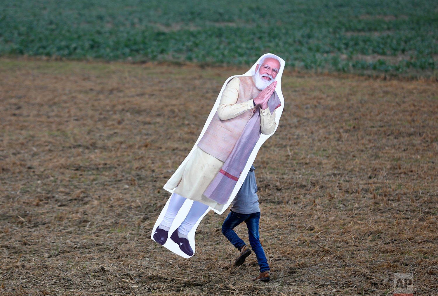  An onlooker runs away with the cut-out of Indian Prime Minister Narender Modi after the inauguration of Purvanchal expressway, in Sultanpur district, 140 kilometers (87 miles) from Lucknow, India, Tuesday, Nov. 16, 2021. (AP Photo/Rajesh Kumar Singh
