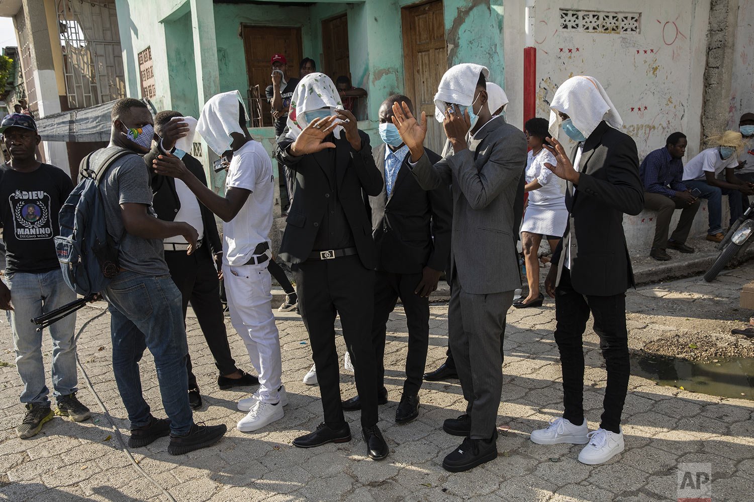  Gang members use hand towels to conceal their identity as they arrive to attend the funeral of fellow gang member Tonino Manino, in Port-au-Prince, Sept. 30, 2021. (AP Photo/Rodrigo Abd) 