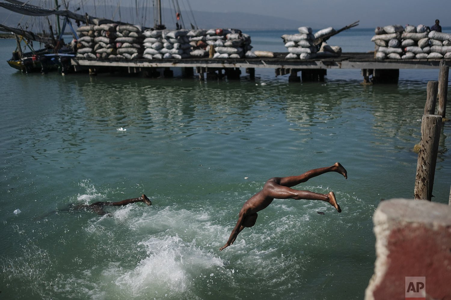  Youths jump into the sea off the shore in the Cite Soleil neighborhood of Port-au-Prince, Haiti, Nov. 16, 2021. (AP Photo/Matias Delacroix) 