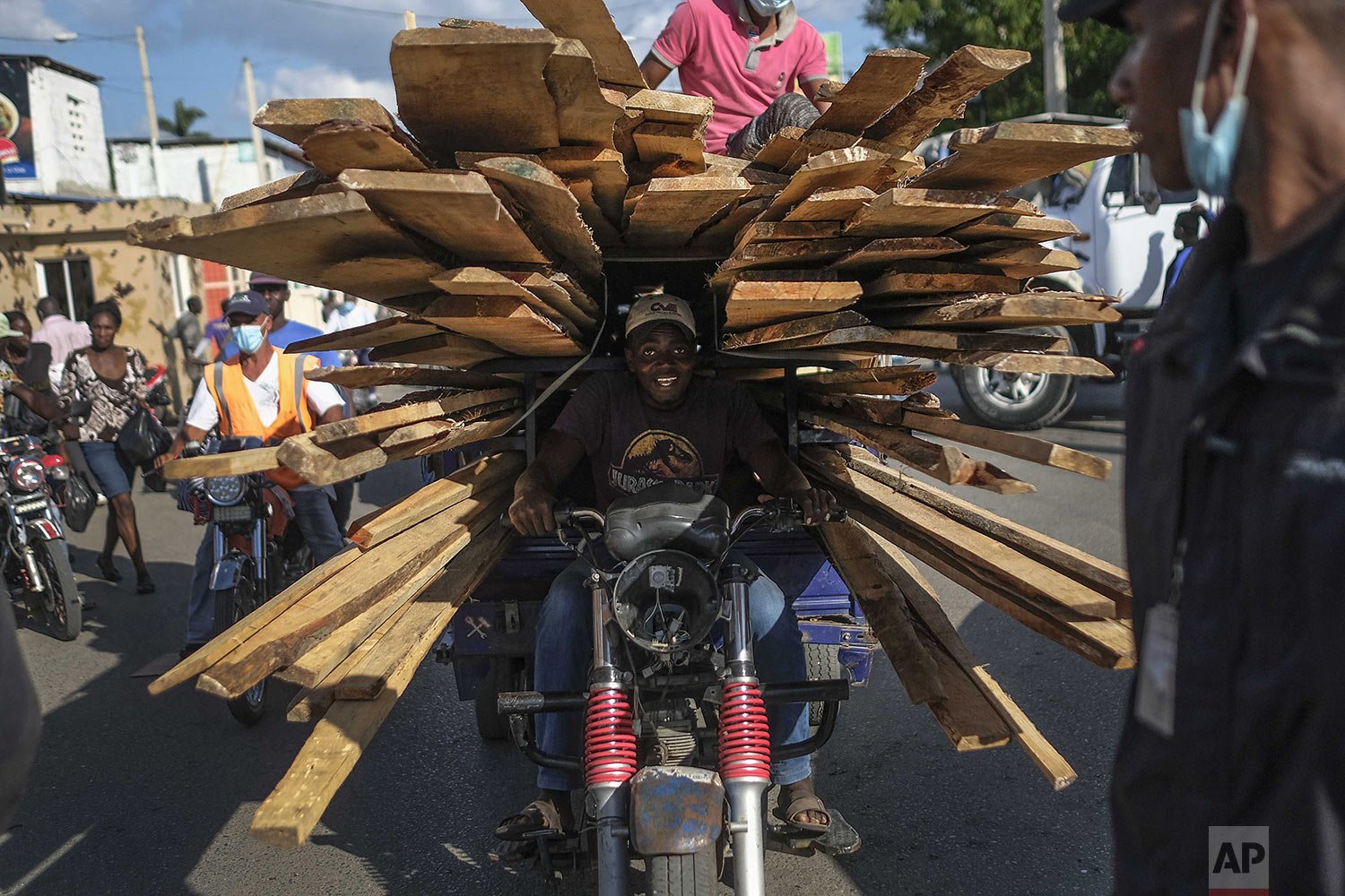  A man returns to Haiti after buying pieces of wood at a market in the border town of Dajabon, Dominican Republic, Nov. 19, 2021.(AP Photo/Matias Delacroix) 