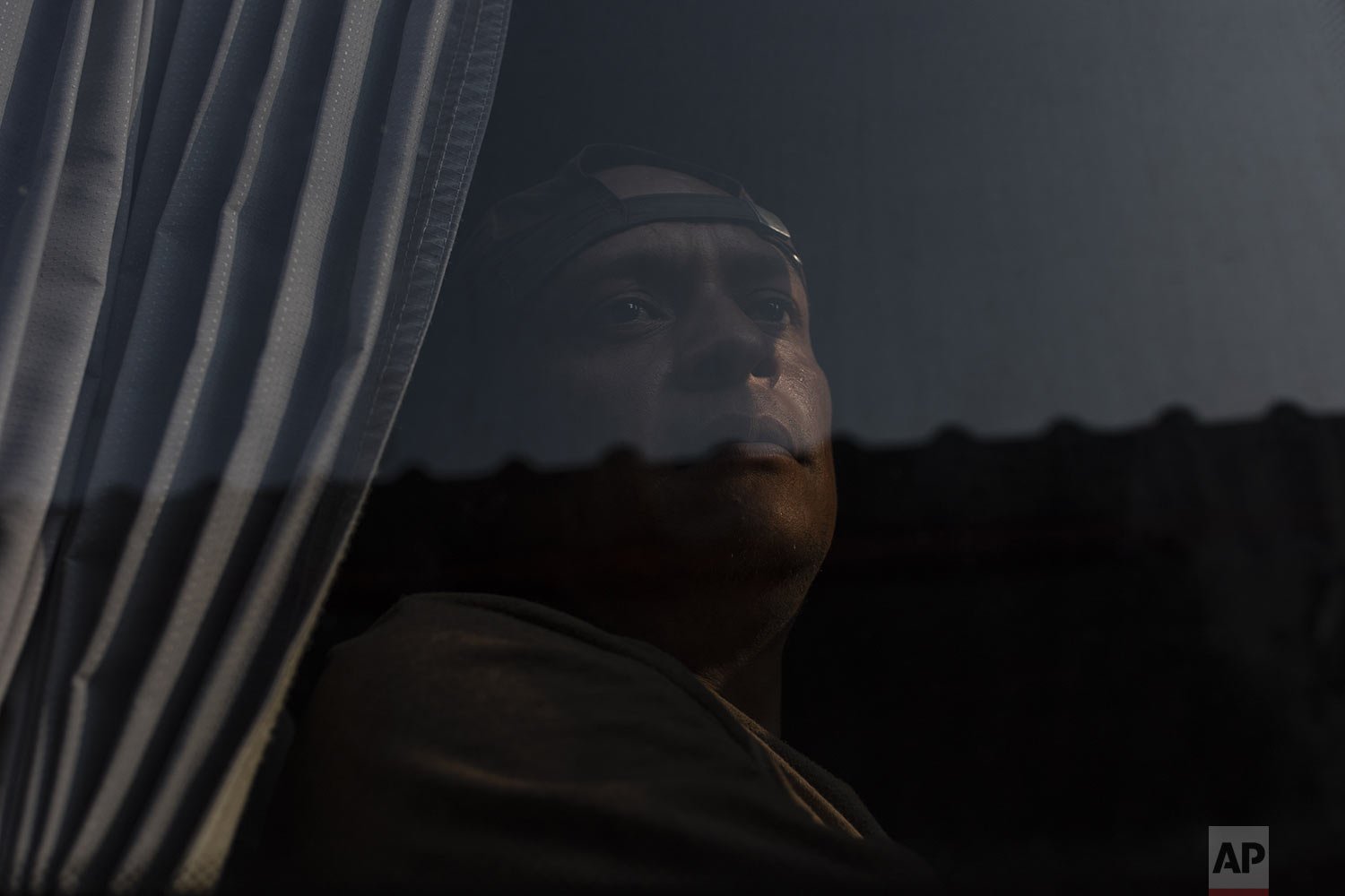  A migrant, who was part of a caravan of mostly Central Americans, looks out from a bus window after abandoning his journey to the U.S. border, in Jesus Carranza, in the Mexican state of Veracruz, Nov. 17, 2021.   (AP Photo/Felix Marquez) 