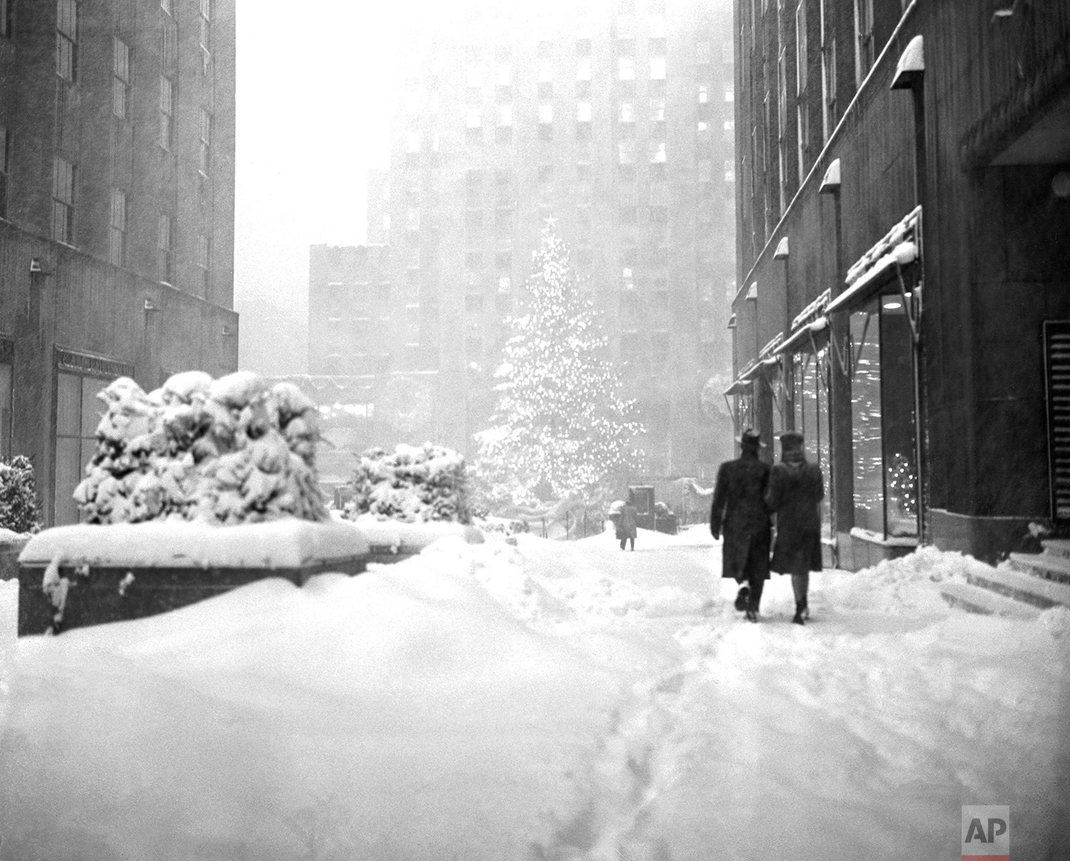  The landmark Christmas tree at New York's Rockefeller Plaza stands out Dec. 26, 1947 as a few hardy pedestrians make their way through the snow drifts of one of the heaviest winter storms in years. (AP Photo/Harry Harris) 