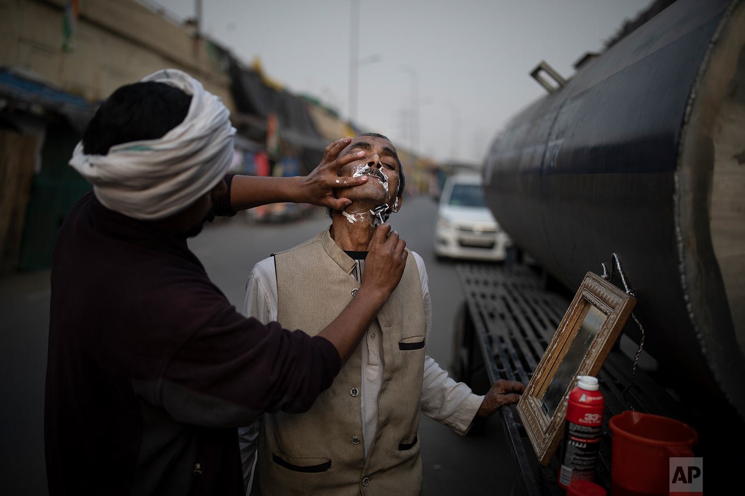  An Indian farmer gets his a shave at the site of protest in Ghazipur, outskirts of New Delhi, India, Thursday, Dec. 9, 2021. (AP Photo/Altaf Qadri) 