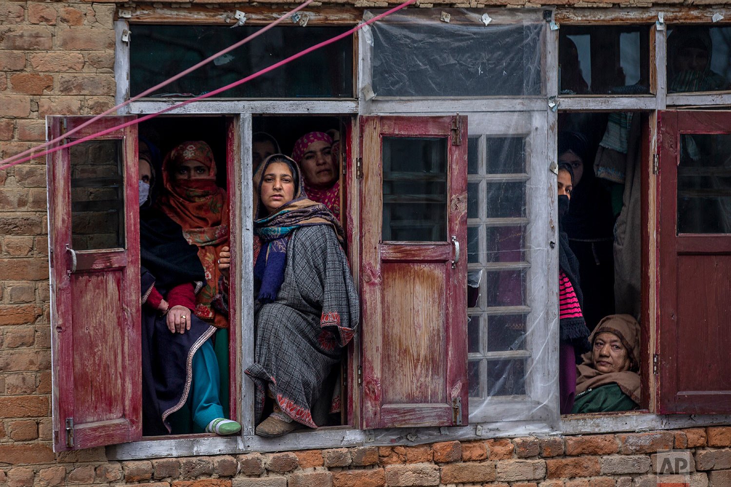  Relatives and neighbors watch the funeral of Rameez Ahmad, a policeman who was killed in Monday's gun attack, in Yachama, northeast of Srinagar, Indian controlled Kashmir, Tuesday, Dec. 14, 2021. (AP Photo/Dar Yasin) 