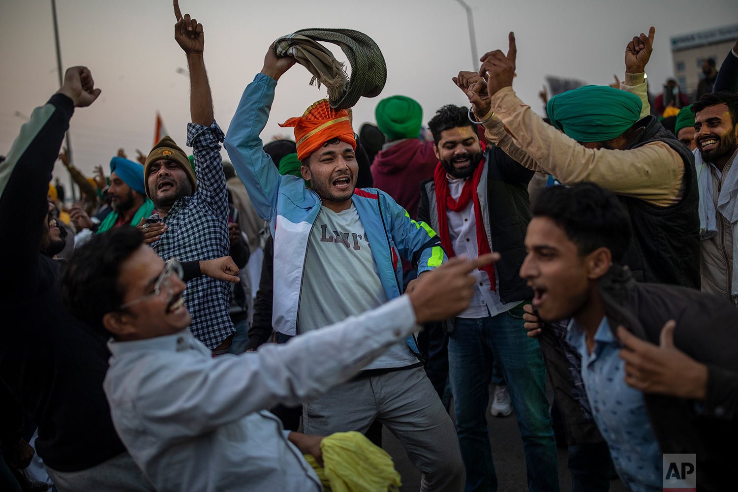  A group of Indian farmers dance at a protest site as they start to dismantle temporary structures used during protests in Ghazipur, on the outskirts of New Delhi, India, Friday, Dec. 10, 2021.  (AP Photo/Altaf Qadri) 
