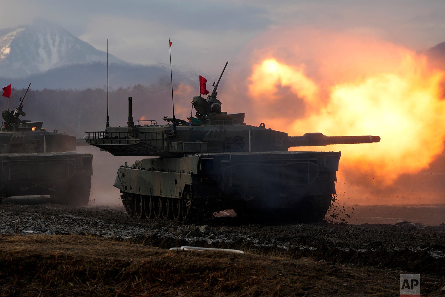 Japanese Ground-Self Defense Force (JGDDF) Type 90 tank fires its gun at a target during an annual drill exercise at the Minami Eniwa Camp Tuesday, Dec. 7, 2021, in Eniwa, Japan's northern island of Hokkaido. (AP Photo/Eugene Hoshiko) 