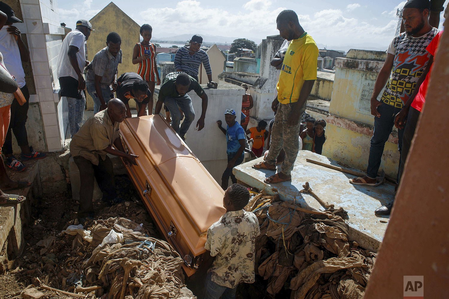  Relatives bury a woman who died in the hospital from her burn injuries caused by a gasoline truck that overturned and exploded, killing dozens in Cap-Haitien Haiti, Dec. 15, 2021. (AP Photo/Odelyn Joseph) 