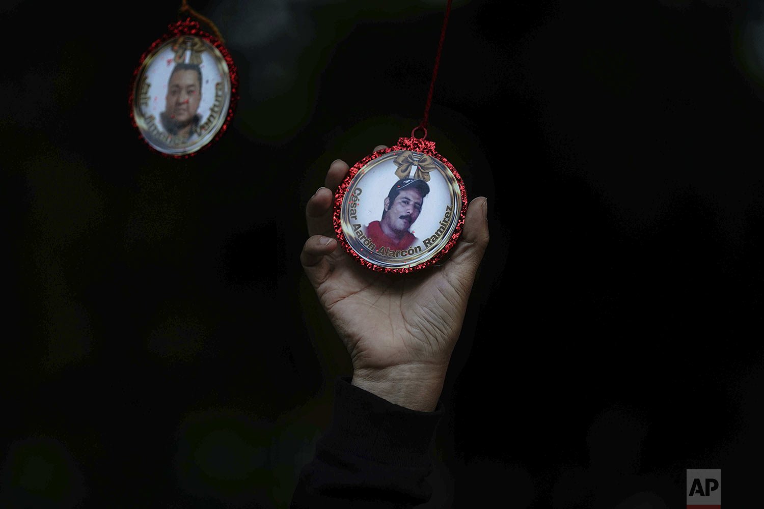  Carmela Lopez holds a Christmas decoration featuring a photo of her missing husband Cesar Alarcon at the Memorial Garden in the Iztacalco borough of Mexico City, Dec. 14, 2021. Cesar Alarcon went missing on July 20, 2020. (AP Photo/Marco Ugarte) 