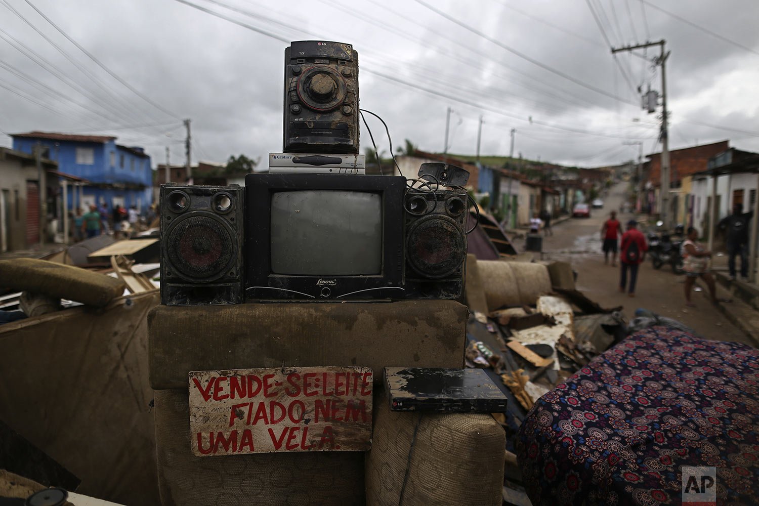  Furniture destroyed by flooding is piled in a street, including an old for sale sign, in Itapetinga, Bahia state, Brazil, Dec. 28, 2021. Two dams broke in northeastern Brazil, threatening worse flooding in a rain-drenched region that has already see