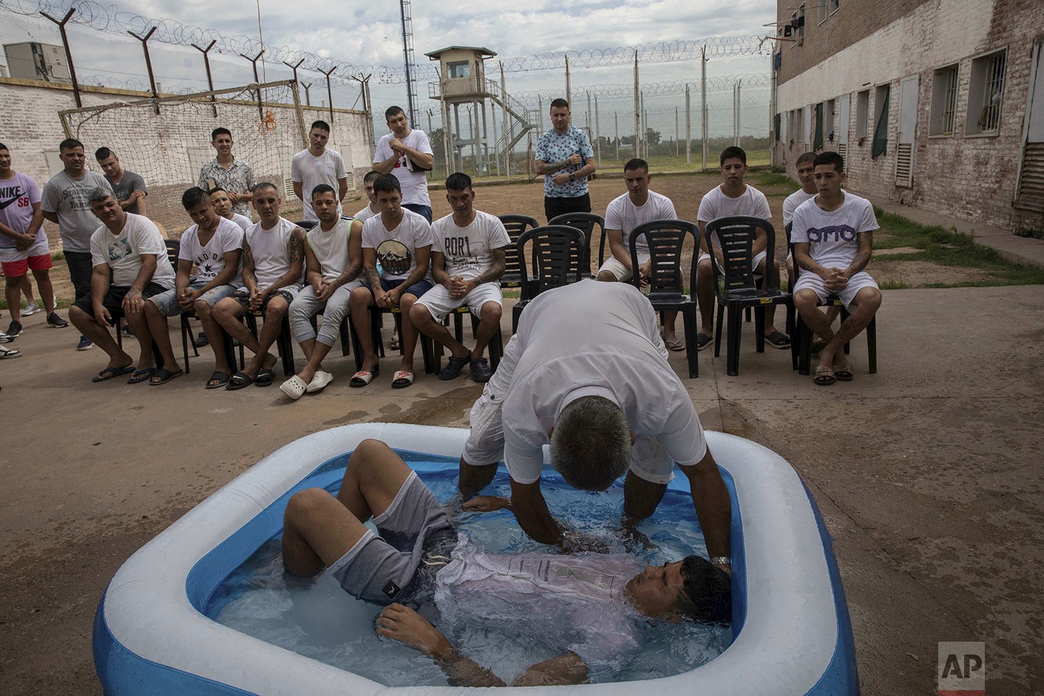  Ruben Munoz, an evangelical pastor from the church Puerta del Cielo, or "Heaven's Door," who served two years in prison for robbery, baptizes an inmate in a kiddie pool, at an evangelical cellblock inside Penal Unit N11 in Pinero, Santa Fe province,