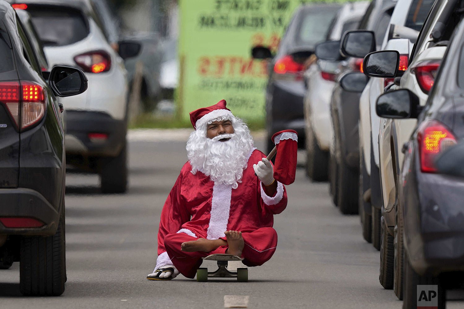  Jose Ivanildo, who lost the use of his legs due to infantile paralysis, uses a skate board as he begs for money at a traffic light dressed as Santa Claus in Brasilia, Brazil, Dec. 21, 2021. The 48-year-old, known as "Ivanildo do Skate," said that th