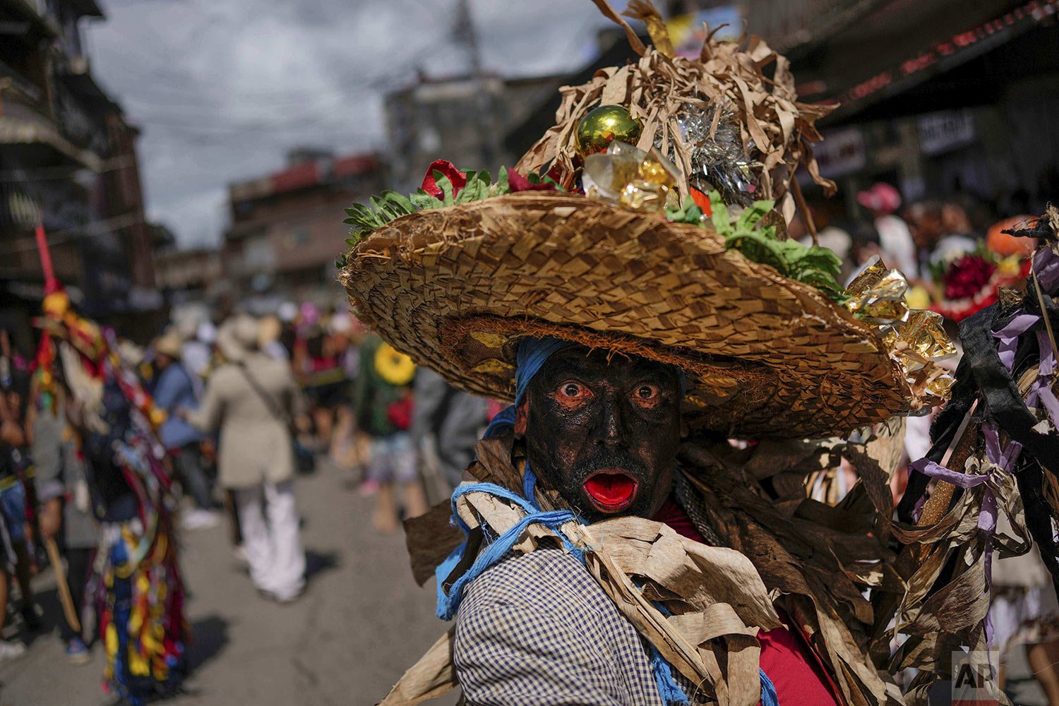  A man dressed as a bolero strikes a pose during festivities during Holy Innocents Day in Caucagua, Venezuela, Dec. 28, 2021. Residents celebrate a variation of the feast day wearing old clothes, painting their faces black and tongues red. The more t