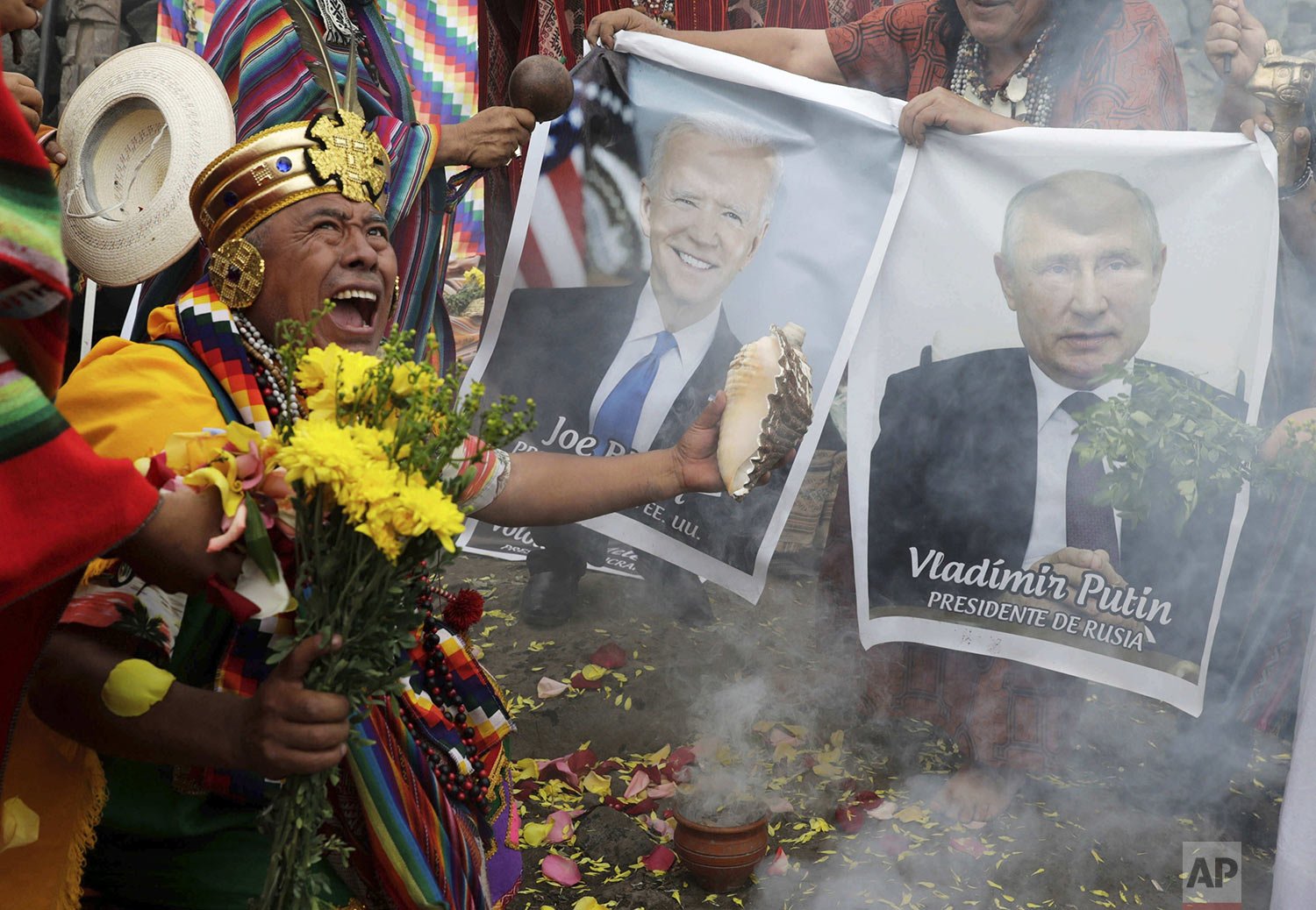 Shamans hold photos of U.S. President Joe Biden and Russia's President Vladimir Putin during a year-end ritual where they predict political and social issues expected to occur in next year in Lima, Peru, Dec. 29, 2021. (AP Photo/Guadalupe Pardo) 
