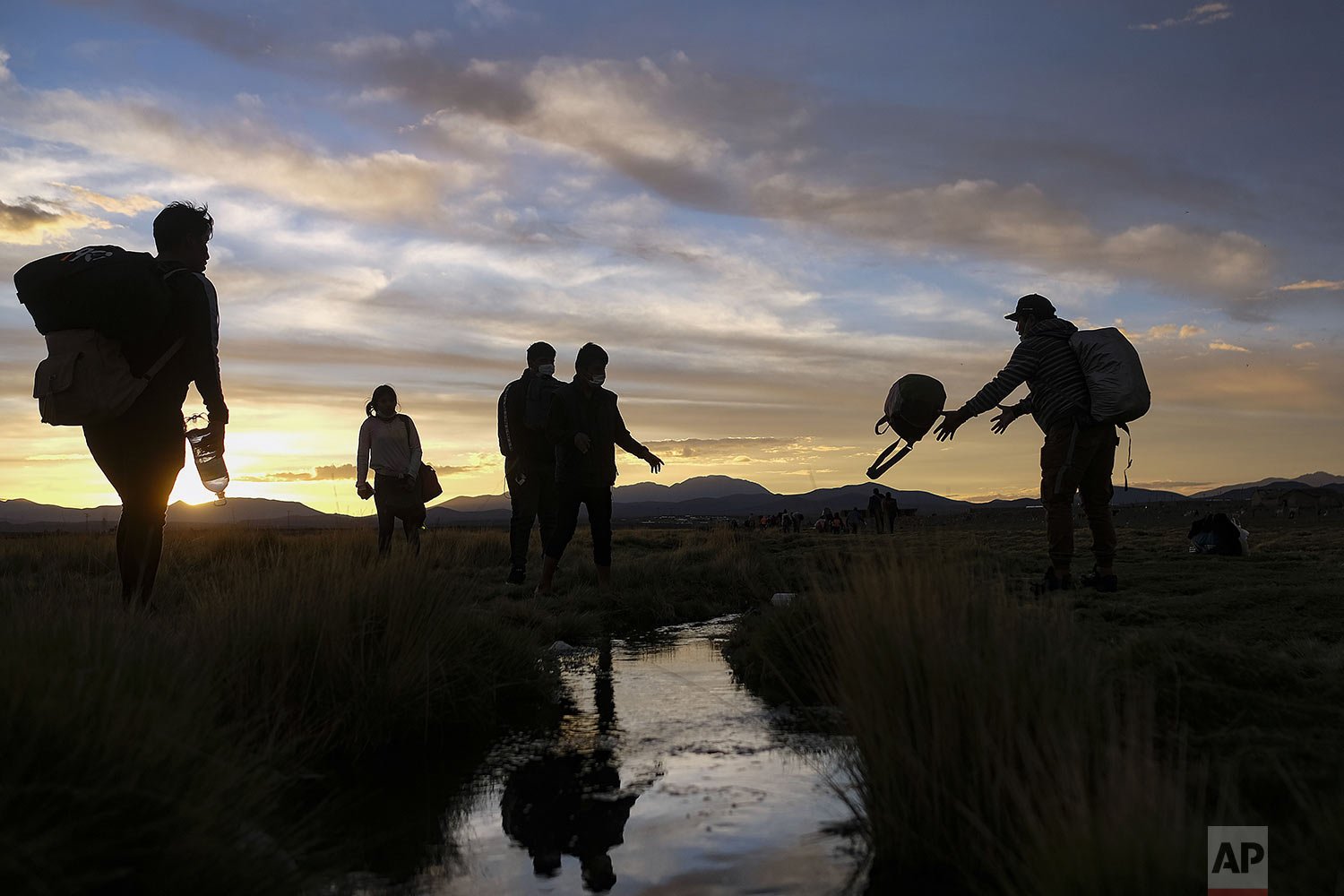  Migrants cross a stream after crossing into Chile from Bolivia, near Colchane, Chile, Dec. 9, 2021. (AP Photo/Matias Delacroix) 
