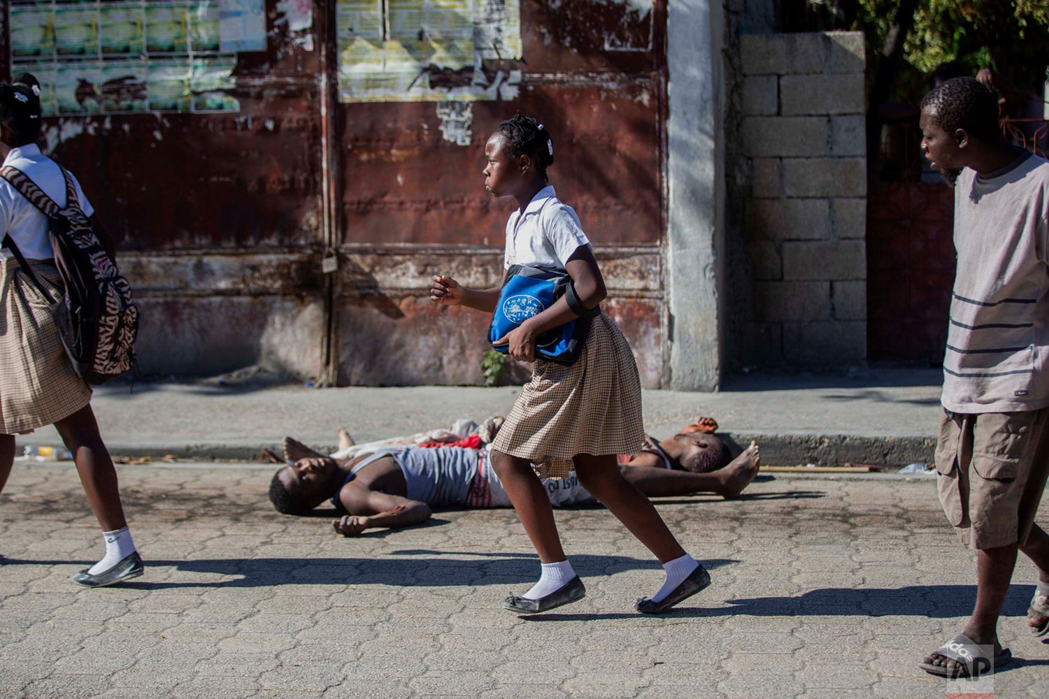  Students rush past the bodies of inmates outside the Croix-des-Bouquets Civil Prison after an attempted breakout, in Port-au-Prince, Haiti, Thursday, Feb. 25, 2021. (AP Photo/Dieu Nalio Chery). 