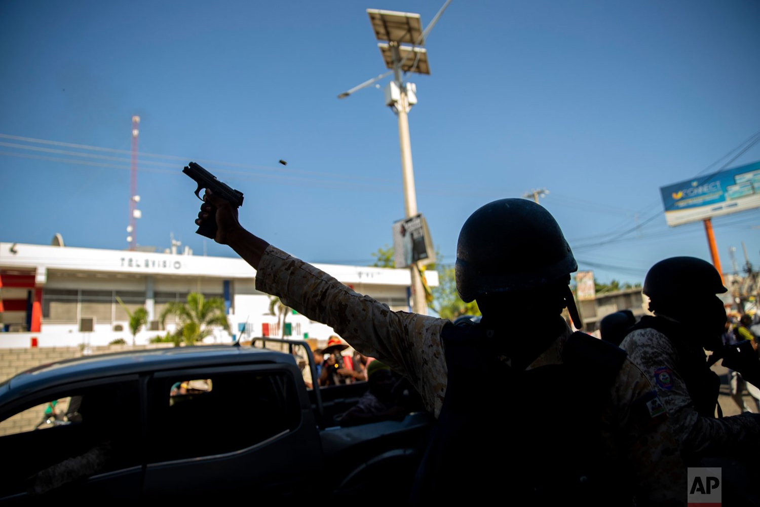  A police officer fires his weapon to disperse demonstrators during a protest to demand the resignation of Haitian President Jovenel Moise in Port-au-Prince, Haiti, Sunday, Feb. 7, 2021. ( AP Photo/Dieu Nalio Chery) 