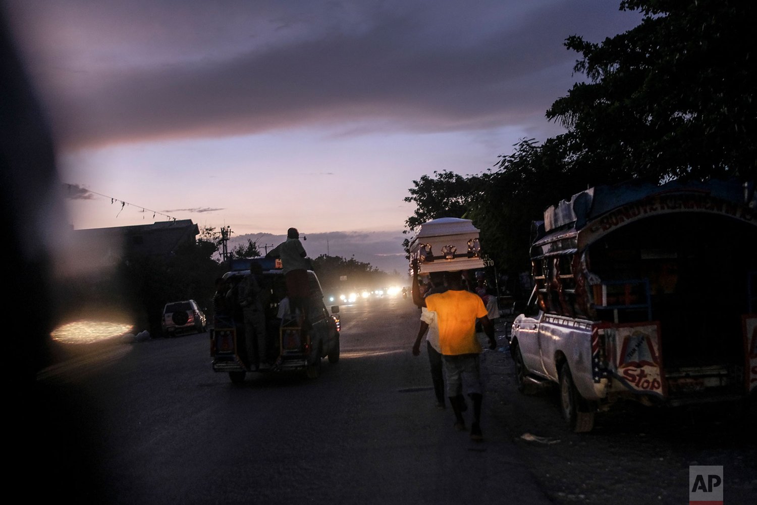  Men carry a coffin amid traffic in Les Cayes, Haiti, Friday, Aug. 20, 2021, six days after a 7.2 magnitude earthquake hit the area. (AP Photo) 