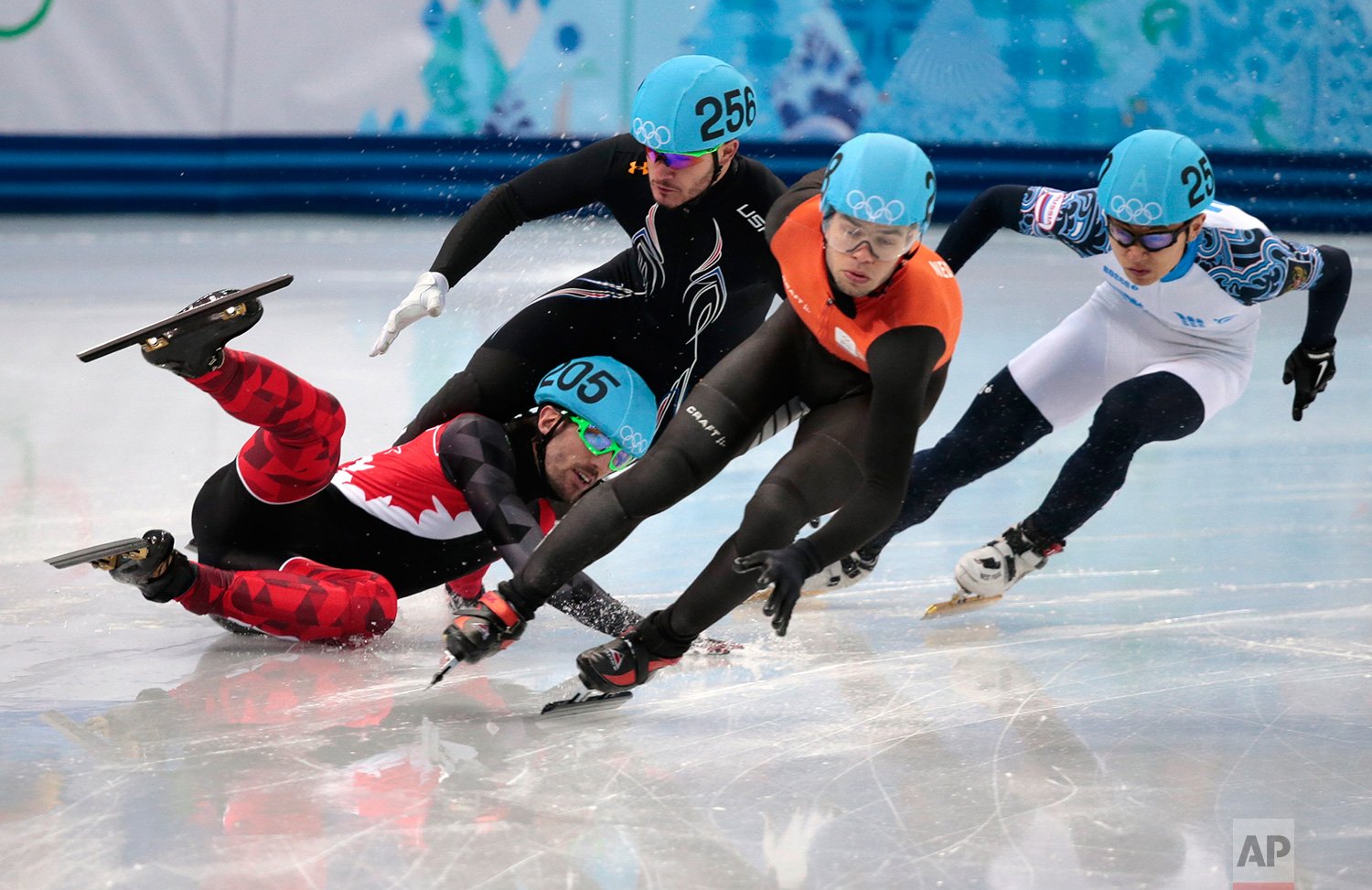  Charles Hamelin of Canada, left, crashes out with Eduardo Alvarez of the United States, second from left, as they compete with Sjinkie Knegt of Netherlands, second from right, and Victor An of Russia in a men's 1000m short track speedskating quarter