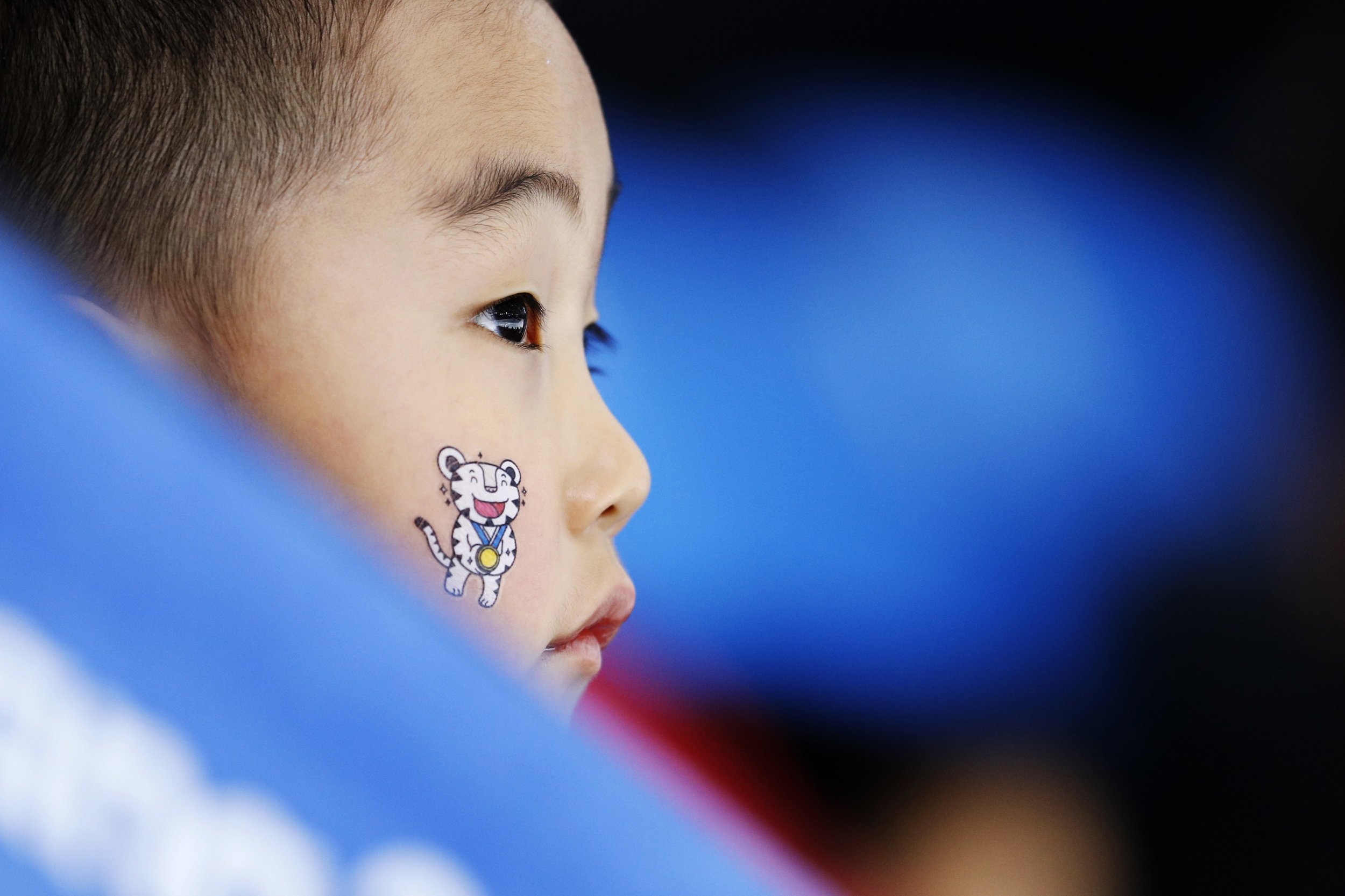  A child wears one of the Olympic mascots on his face when watching the women's 1,500-meter speedskating race at the Gangneung Oval at the 2018 Winter Olympics in Gangneung, South Korea, Feb. 12, 2018. (AP Photo/John Locher) 