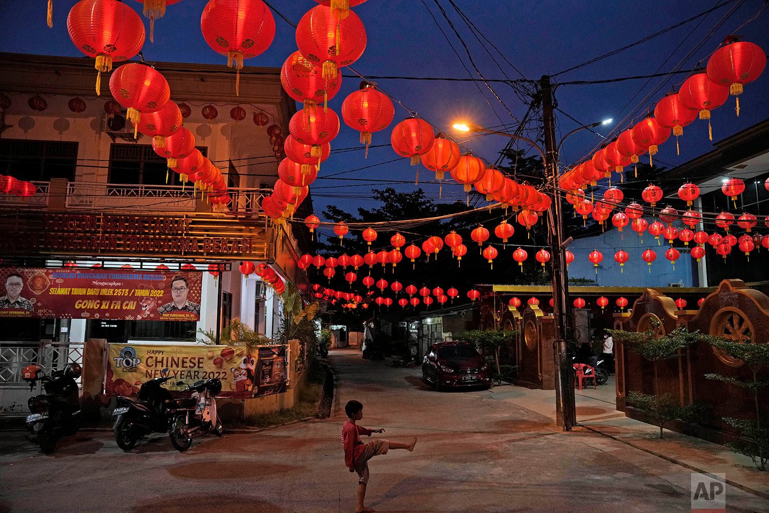 A young boy plays under lanterns decorating Hok Lay Kiong temple on the evening of Chinese New year, in Bekasi, Indonesia, Monday, Jan. 31, 2022. (AP Photo/Dita Alangkara) 