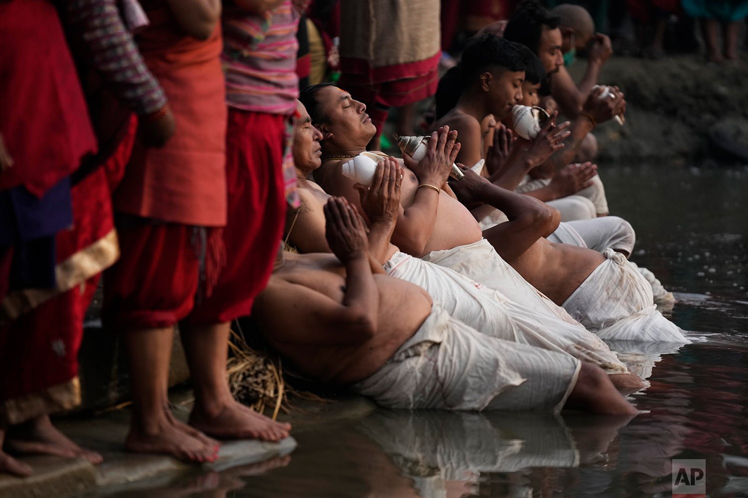  Nepalese Hindu devotees offer prayers dipping half of their bodies into the Hanumante river during Madhav Narayan Festival in Bhaktapur, Nepal, Monday, Jan. 17, 2022.  (AP Photo/Niranjan Shrestha) 