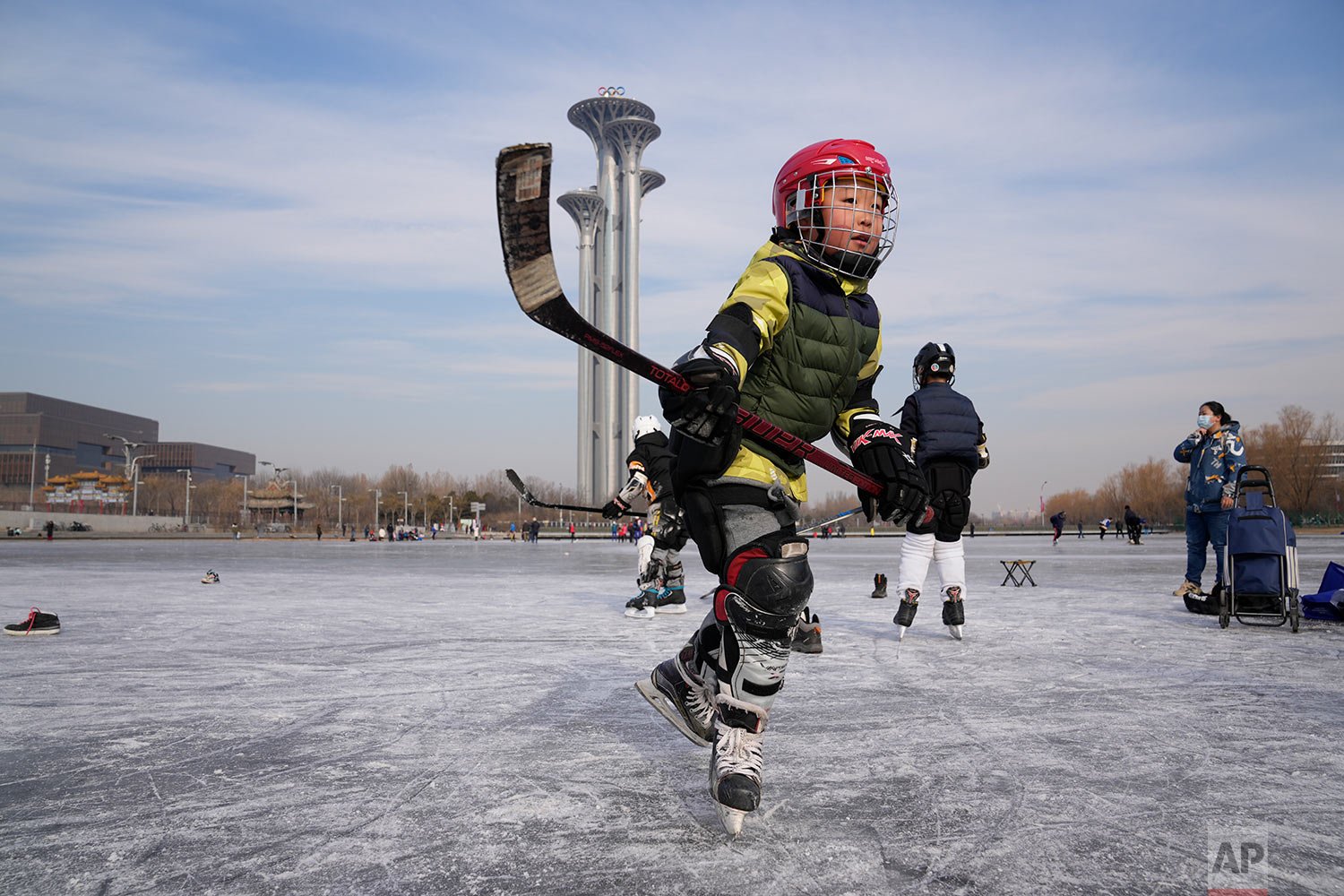  A child practices ice hockey near the Beijing Olympics Tower in Beijing, China, Tuesday, Jan. 18, 2022. (AP Photo/Ng Han Guan) 