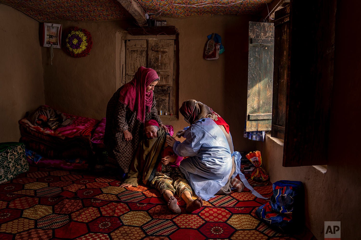  Arsha Begum, An elderly Kashmiri woman, receives the Covishield COVID-19 vaccine from healthcare worker Fozia during a COVID-19 vaccination drive in Budgam, southwest of Srinagar, Indian controlled Kashmir, Jan. 11, 2022. (AP Photo/Dar Yasin) 
