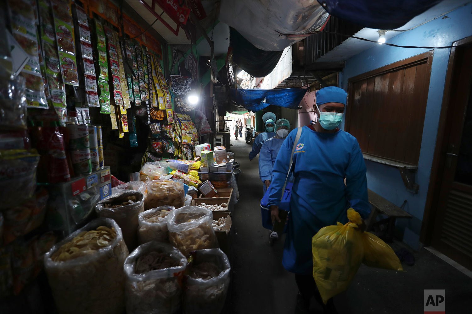  Health workers walk through a market as they conduct mass coronavirus tests in Jakarta, Indonesia, Monday, Jan. 10, 2022. (AP Photo/Achmad Ibrahim) 