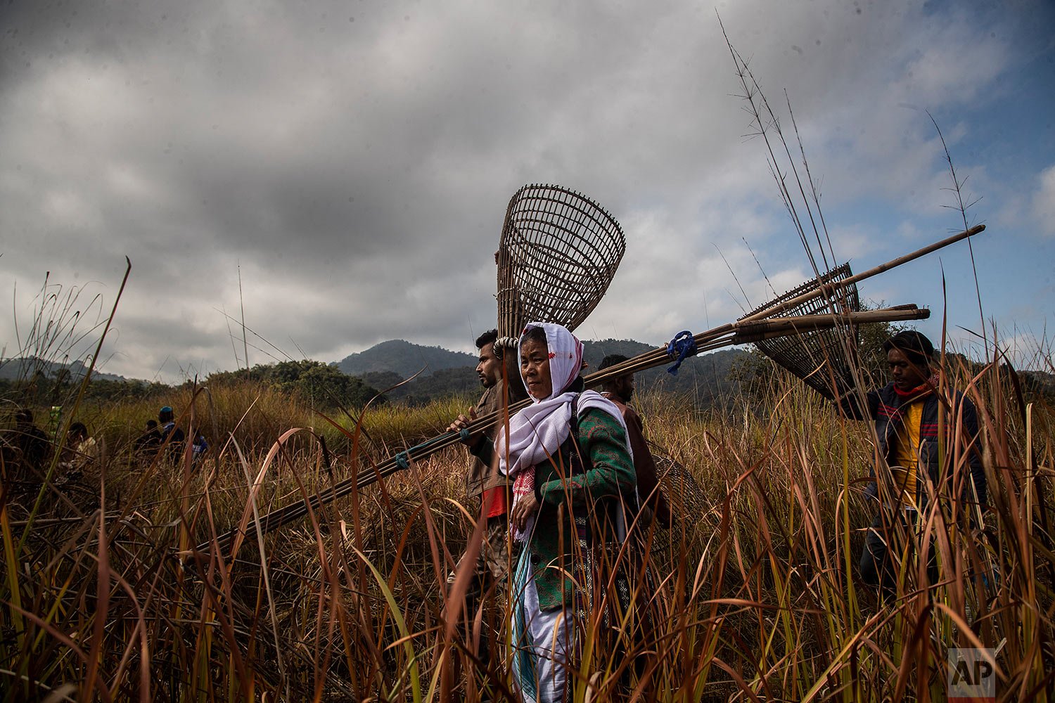  Indian villagers arrive with fishing tools to participate in community fishing as part of Bhogali Bihu celebrations, marking the end of the harvest season,  in Panbari village, some 50 kilometers (31 miles) east of Gauhati, India, Thursday, Jan. 13,