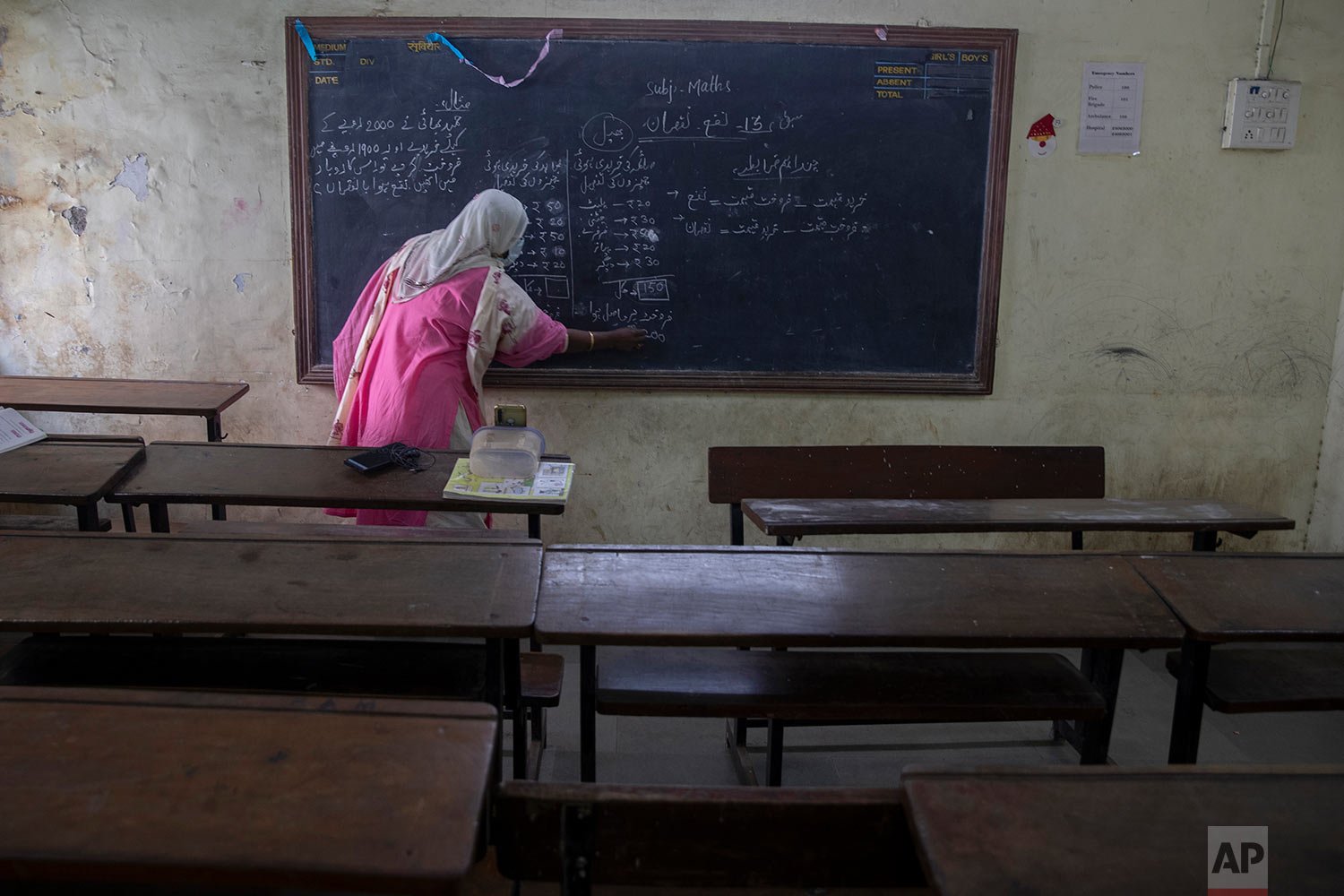  A teacher, working at a government, school gives an online class inside an empty class room amid a surge in COVID-19 cases, in Dharavi, Asia's largest slum in Mumbai, India, Tuesday, Jan. 4, 2022.  (AP Photo/Rafiq Maqbool) 
