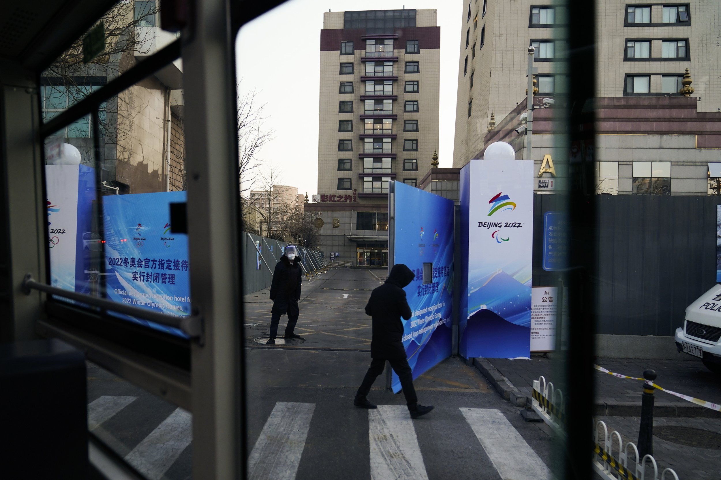  A guard opens the gate as an Olympic shuttle bus pulls into a hotel walled in by fences ahead of the 2022 Winter Olympics, Saturday, Jan. 29, 2022, in Beijing. (AP Photo/Jae C. Hong) 