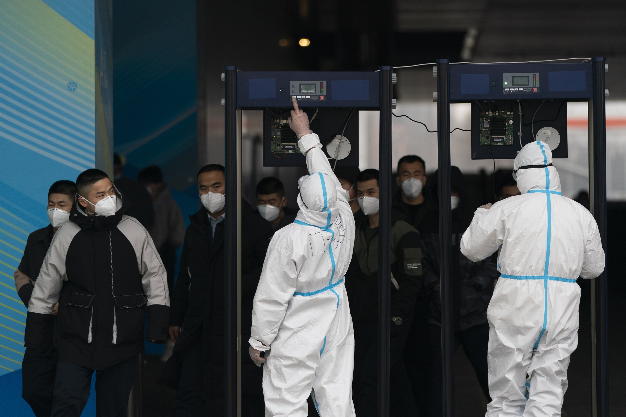  Two security personnel in protective gear set up metal detectors at the main media center at the 2022 Winter Olympics, Monday, Jan. 24, 2022, in Beijing. (AP Photo/Jae C. Hong) 