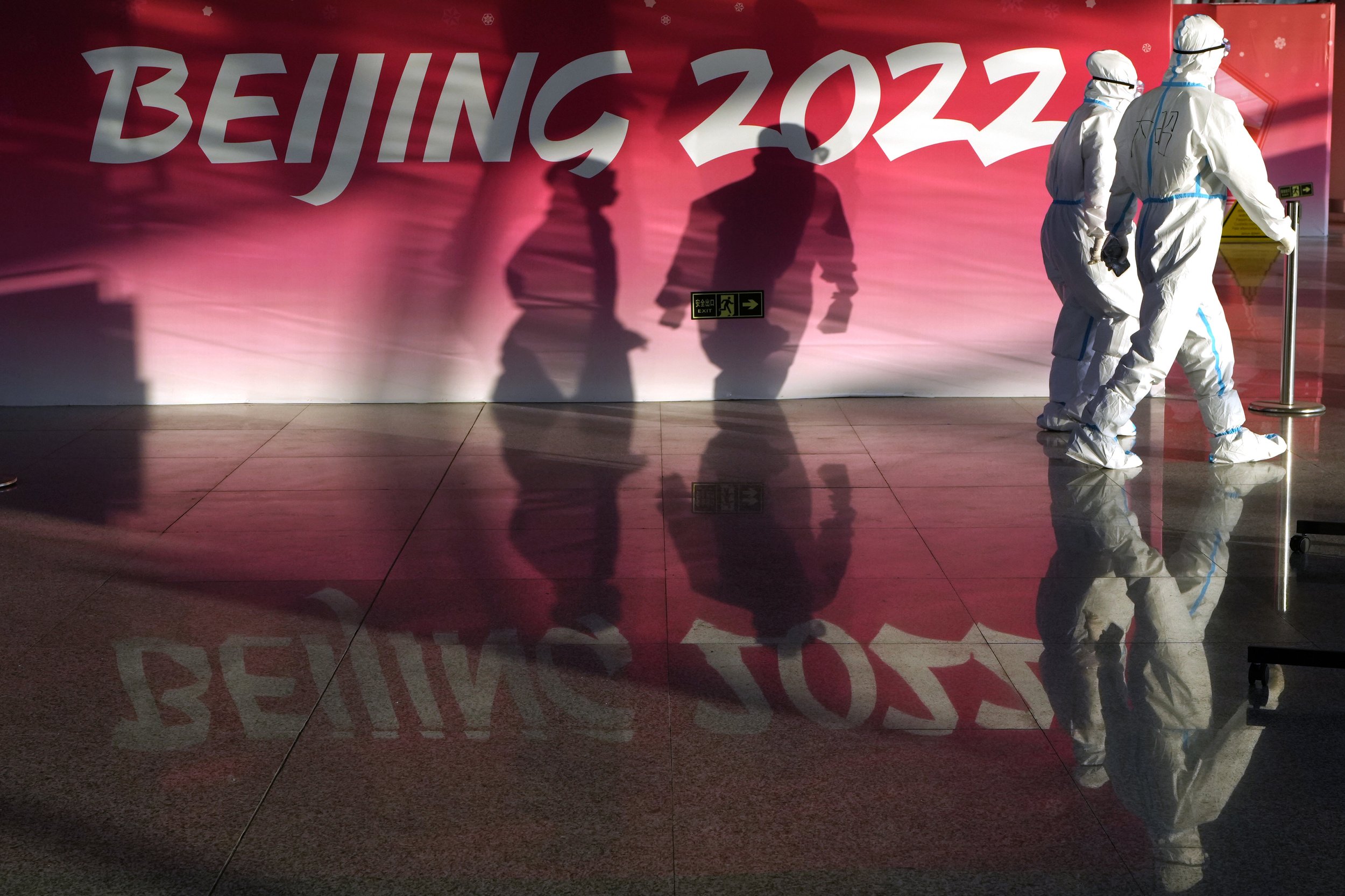 Olympic workers in protective gear walk through the Beijing Capital International Airport as they work to assist passengers ahead of the 2022 Winter Olympics, in Beijing, on Monday, Jan. 31, 2022. (AP Photo/Kirsty Wigglesworth) 