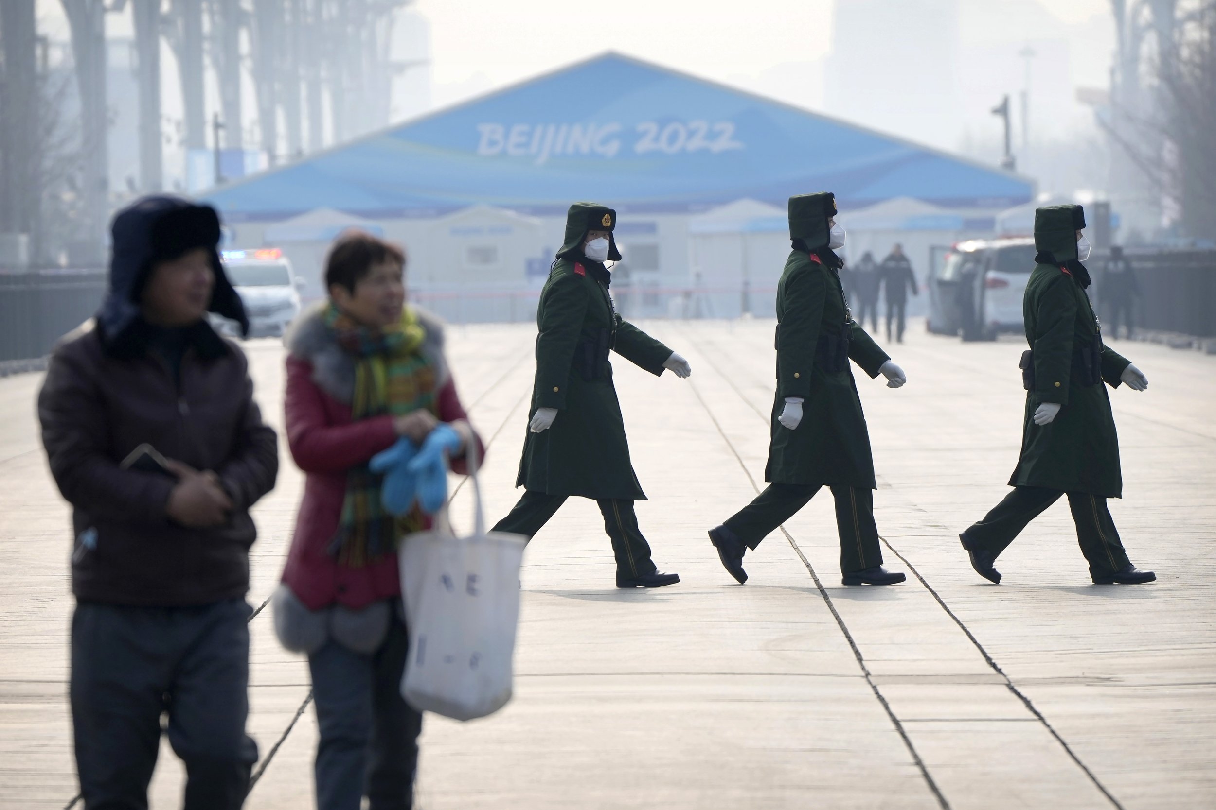  Chinese paramilitary police walk in formation on the Olympic Green near the edge of the closed-loop area at the 2022 Winter Olympics in Beijing, Sunday, Jan. 30, 2022. (AP Photo/Mark Schiefelbein) 