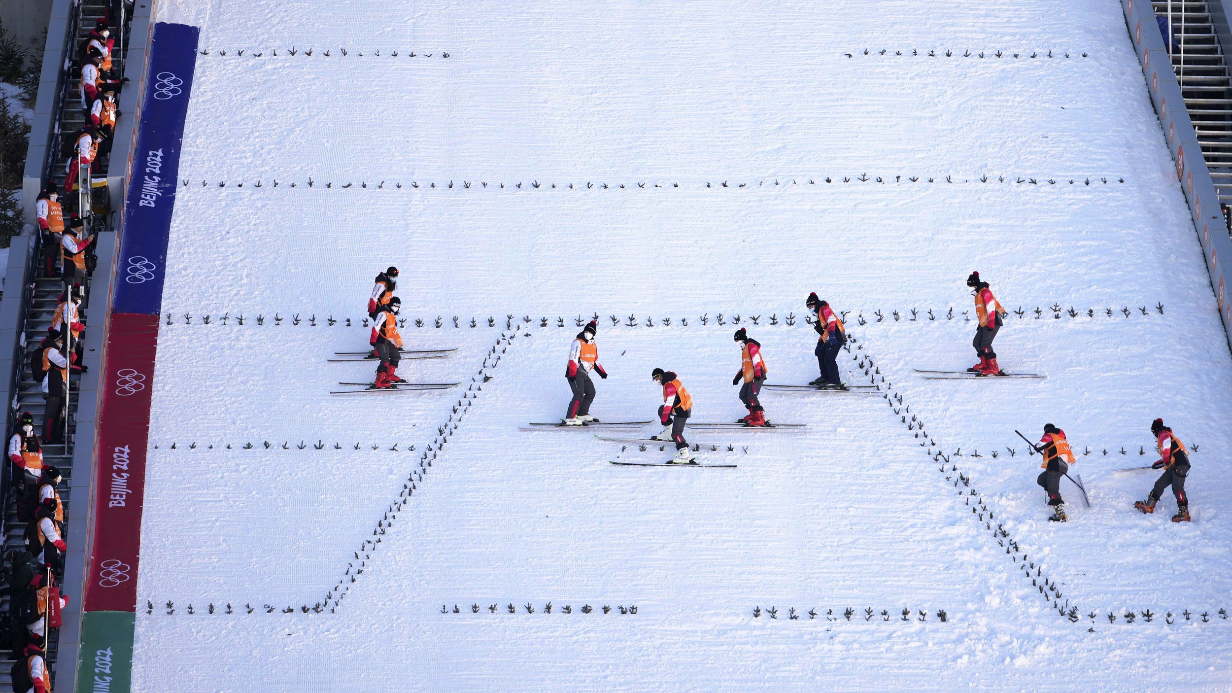  Volunteers prepare the ski jumping hill ahead of the 2022 Winter Olympics, Feb. 1, 2022, in Zhangjiakou, China. (AP Photo/Matthias Schrader) 