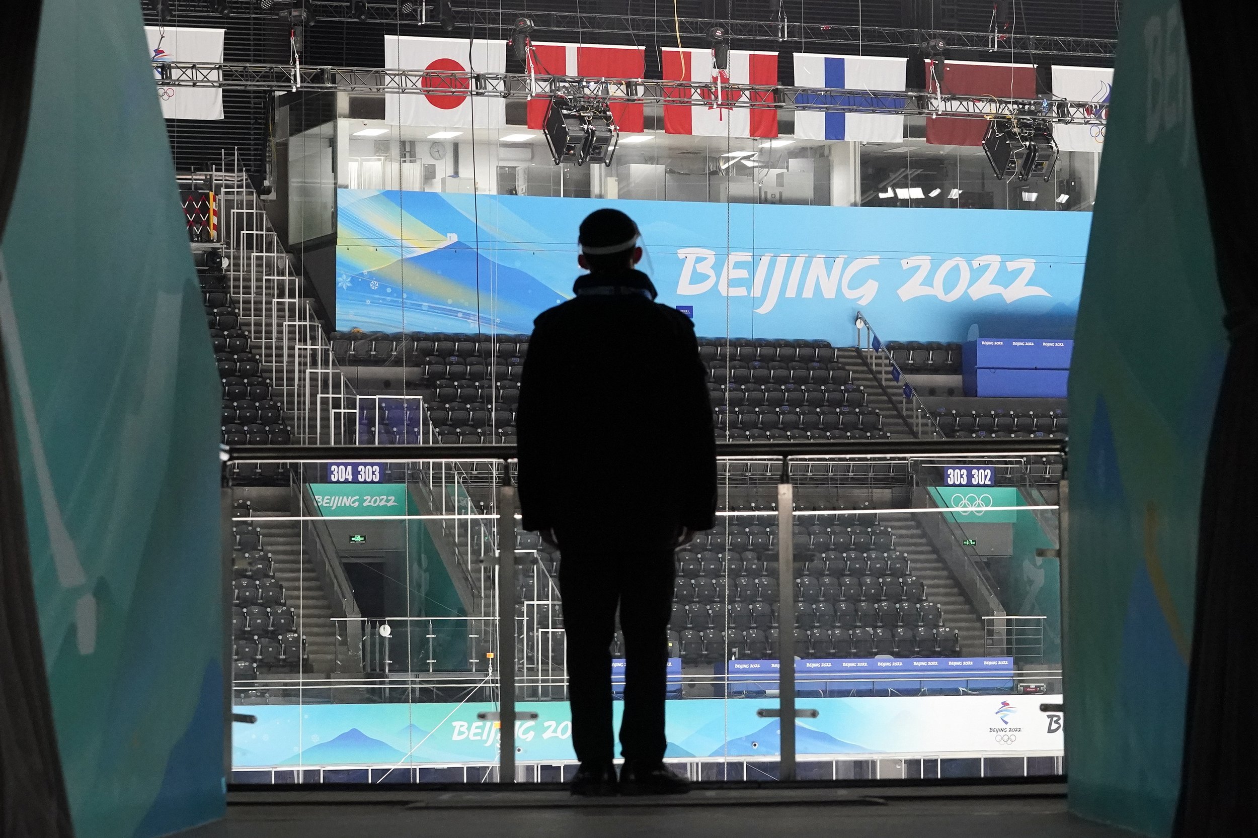  A man watches as the National Indoor Stadium is prepared for ice hockey at the 2022 Winter Olympics, Jan. 31, 2022, in Beijing. (AP Photo/Mark Humphrey) 