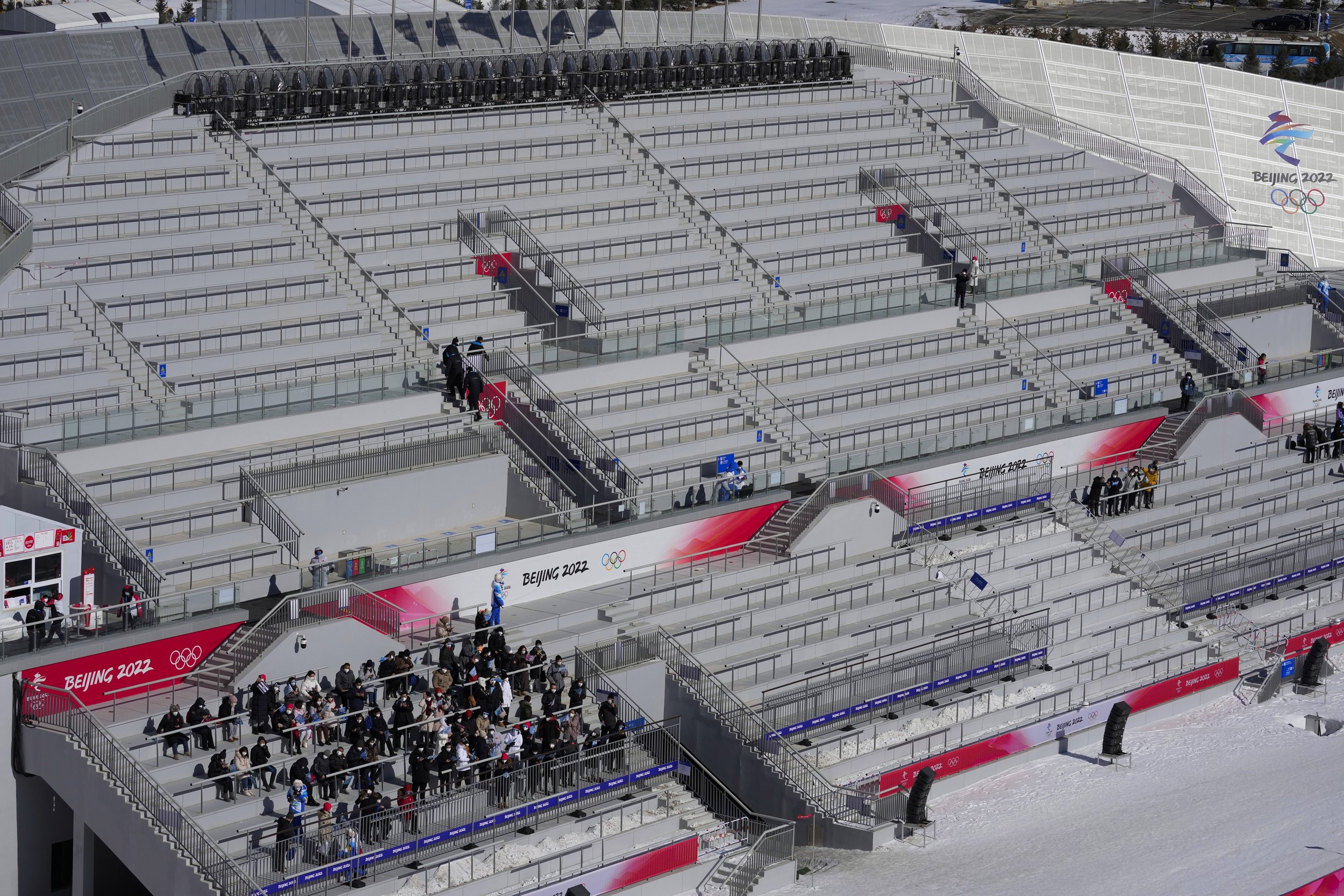  People watch the during the men's normal hill individual ski jumping trial round in a nearly empty Zhangjiakou National Ski Jumping Centre at the 2022 Winter Olympics, Saturday, Feb. 5, 2022, in Zhangjiakou, China. (AP Photo/Andrew Medichini) 
