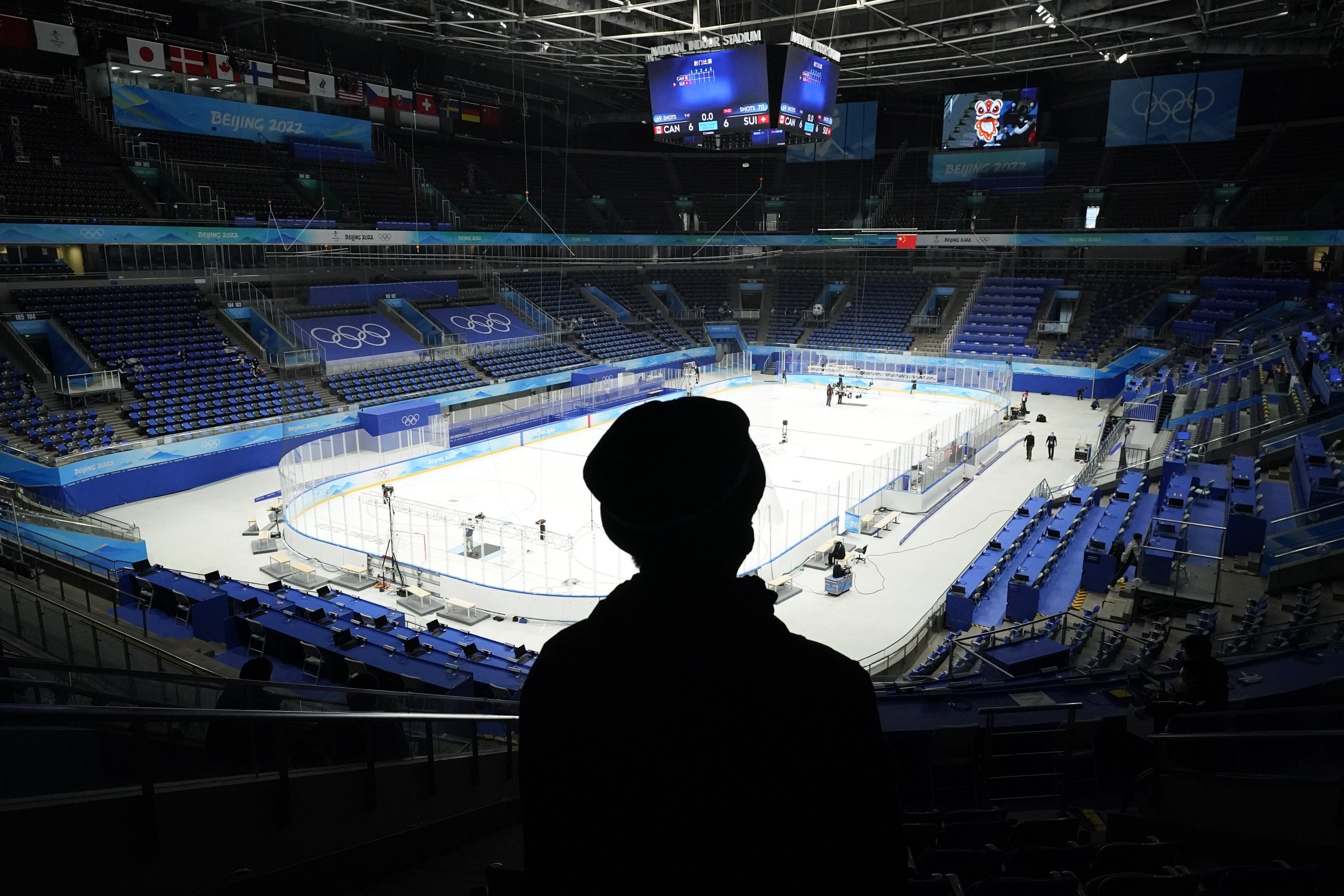  A man watches as the National Indoor Stadium is prepared for ice hockey at the 2022 Winter Olympics, Monday, Jan. 31, 2022, in Beijing. (AP Photo/Mark Humphrey) 