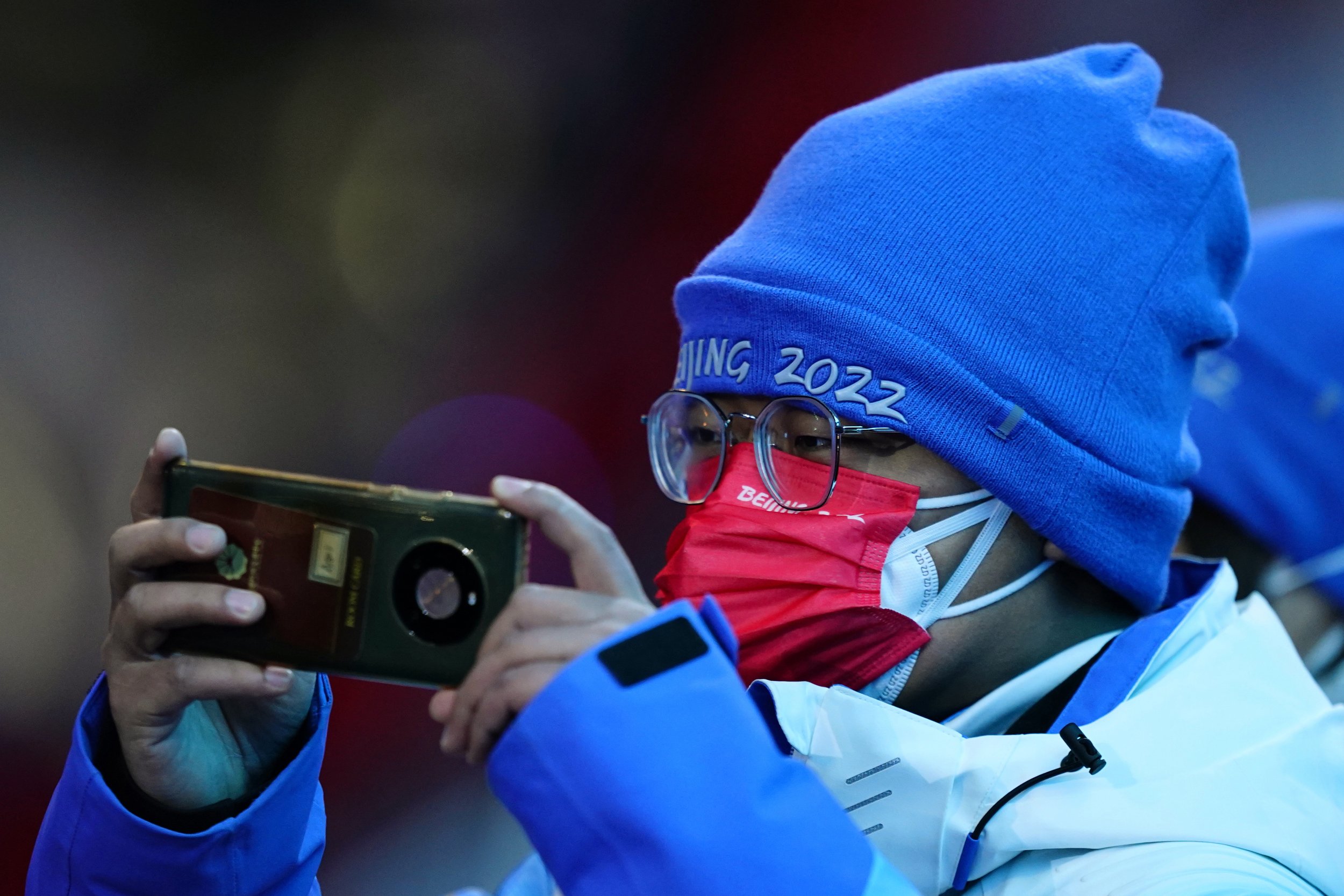  A spectator takes a photo during the pre-show ahead of the opening ceremony of the 2022 Winter Olympics, Friday, Feb. 4, 2022, in Beijing. (AP Photo/Matt Slocum) 