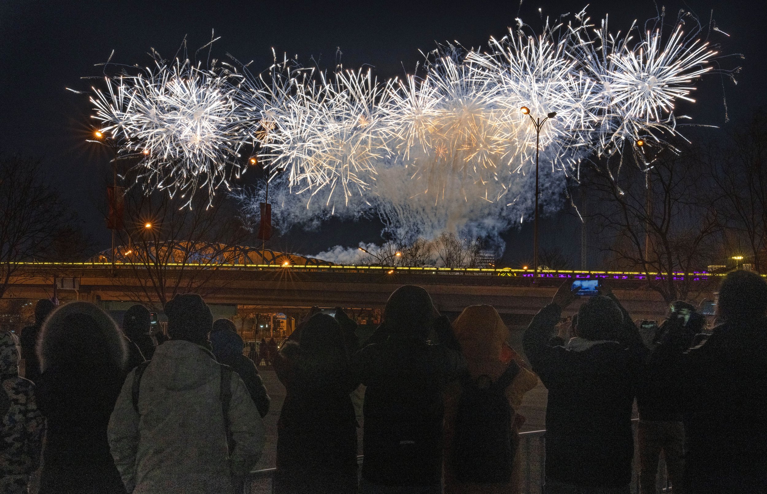  A crowd watches as fireworks explode at the opening ceremony of the 2022 Winter Olympics, Friday, Feb. 4, 2022, in Beijing. (AP Photo/Ng Han Guan) 