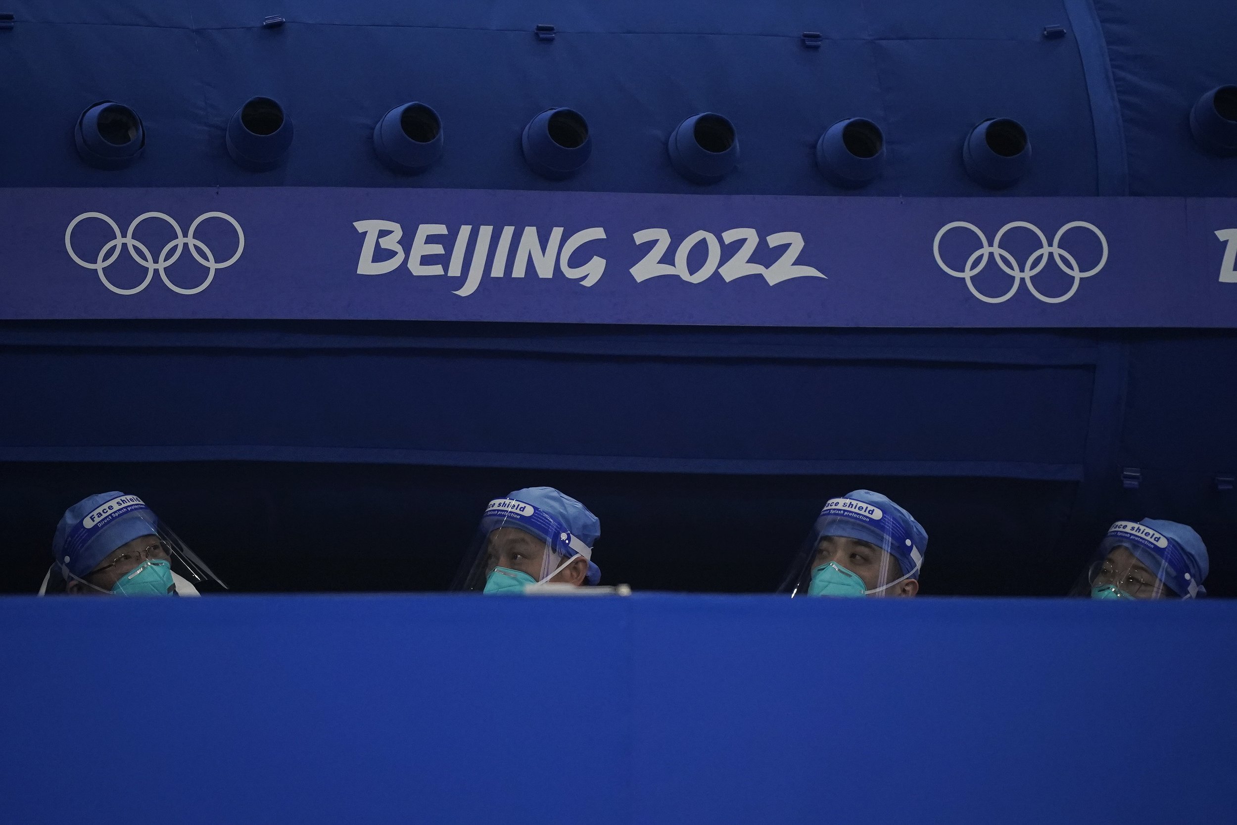  A group of medical staff sits in the curling arena during the mixed doubles curling match at the Beijing Winter Olympics Sunday, Feb. 6, 2022, in Beijing. (AP Photo/Brynn Anderson) 