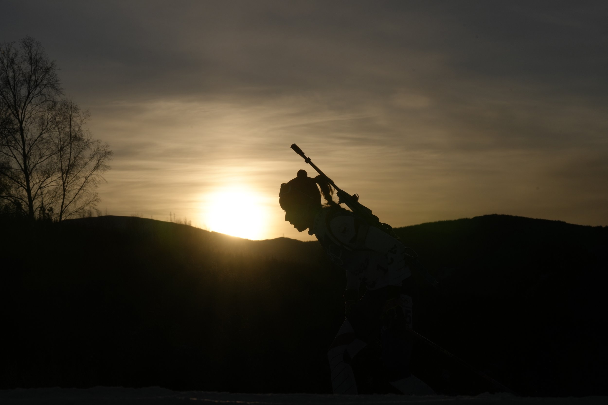  A biathlete is silhouetted against the setting sun during the women's 15-kilometer individual race at the 2022 Winter Olympics, Monday, Feb. 7, 2022, in Zhangjiakou, China. (AP Photo/Kirsty Wigglesworth) 