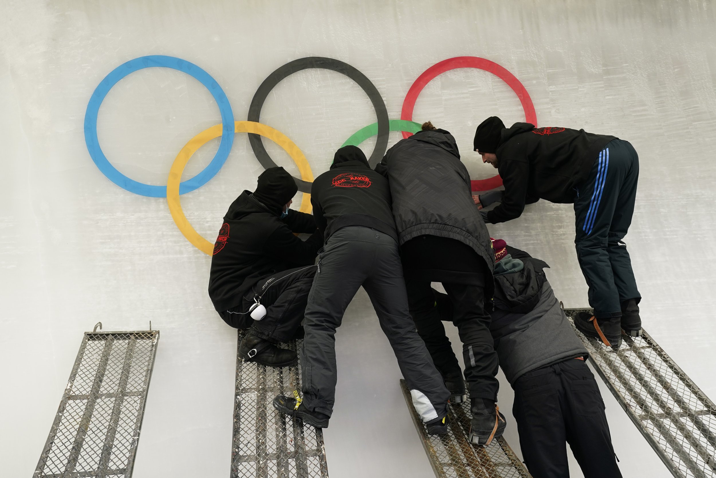  Ice makers apply a cutout of the Olympic rings onto the track at the Yanqing National Sliding Center ahead of the 2022 Winter Olympics, Friday, Jan. 28, 2022, in the Yanqing district of Beijing. (AP Photo/Jae C. Hong) 